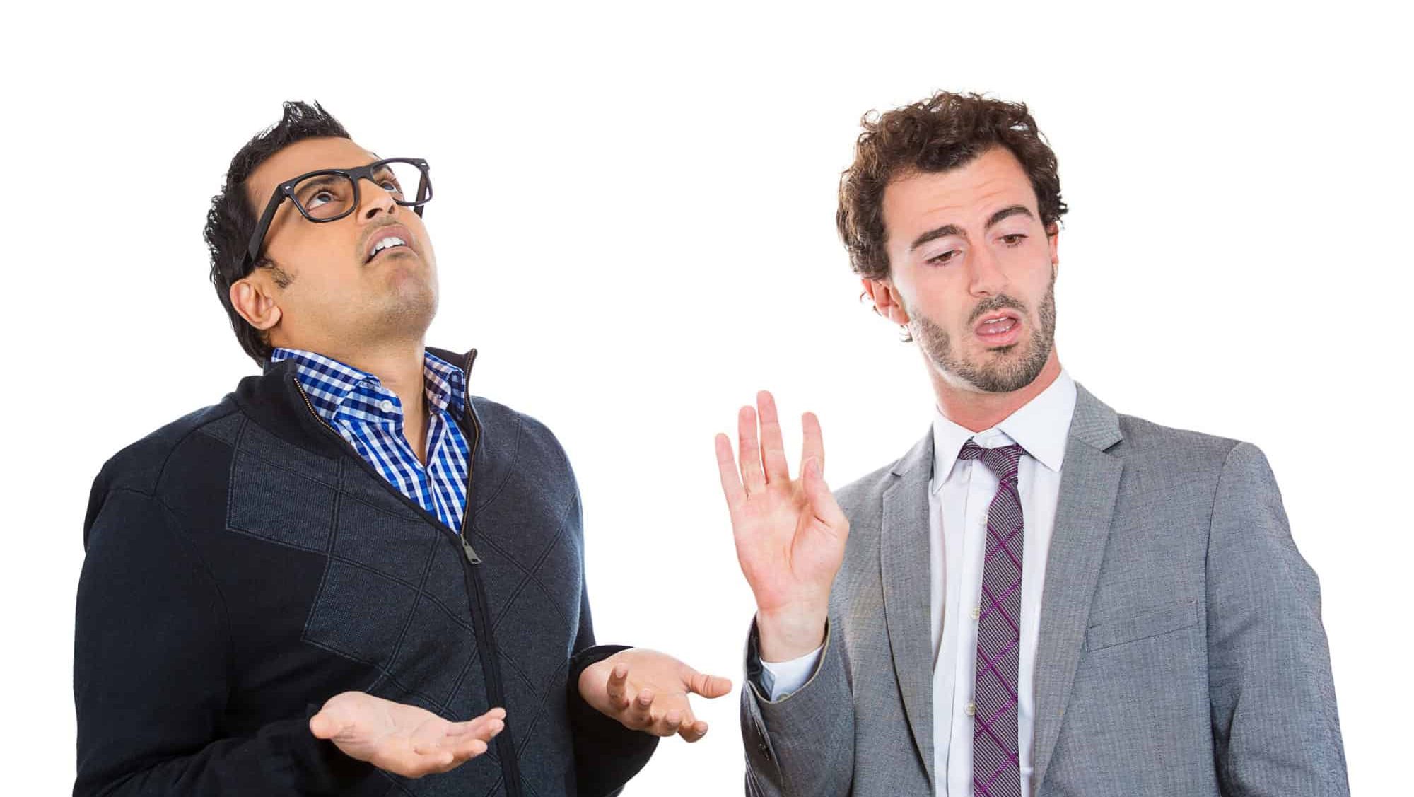 Closeup portrait, annoyed nerd man with black glasses by what a business guy in suit is telling him, talk to hand, isolated white background. Negative human emotion facial expression feelings.