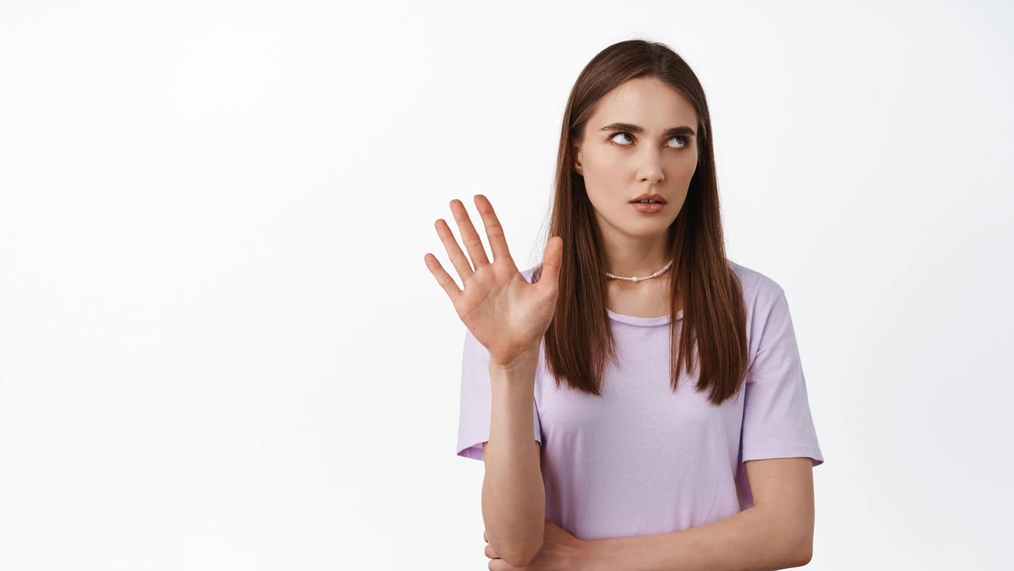 Stop talking. Blah blah so annoying. Young arrogant woman roll her eyes and raising hand to block, refusing to listen, thats enough, bored with conversation, white background