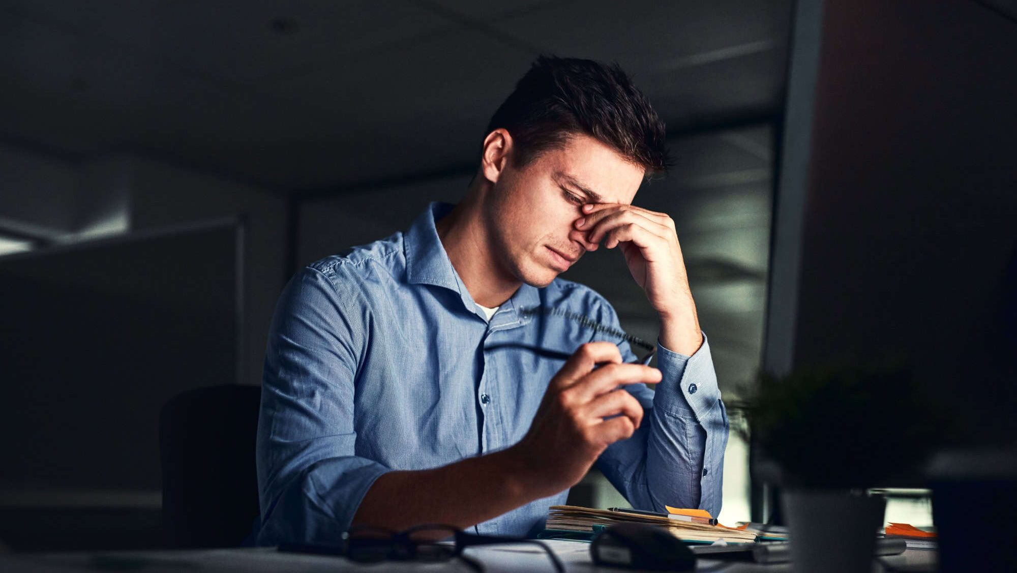 Putting in those overtime hours. Shot of a young businessman working late at night in a modern office.