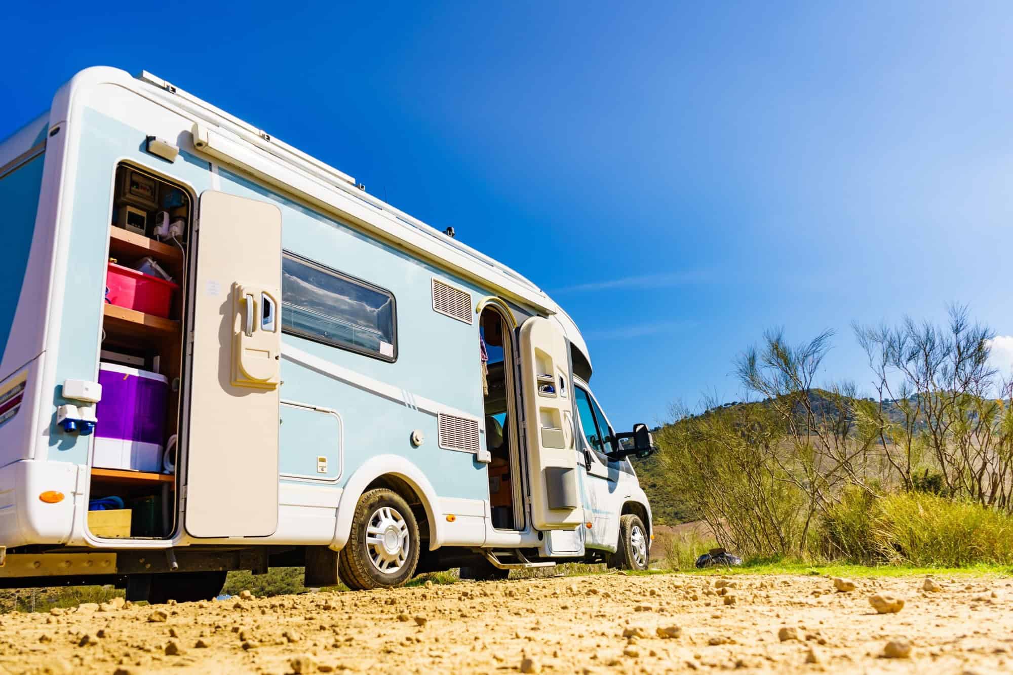 Camper rv with open storage box camping on nature, Spain. Adventure with motor home.