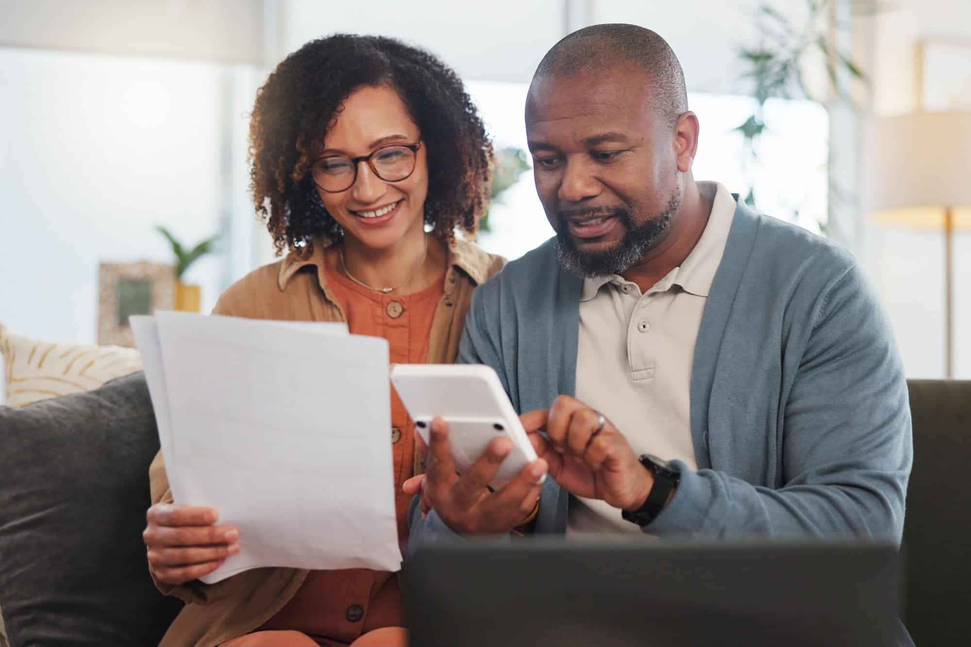 Home, documents and senior couple with laptop, calculator and financial planning. Apartment, man and woman with paperwork, budget and retirement fund with internet, connection and taxes in lounge