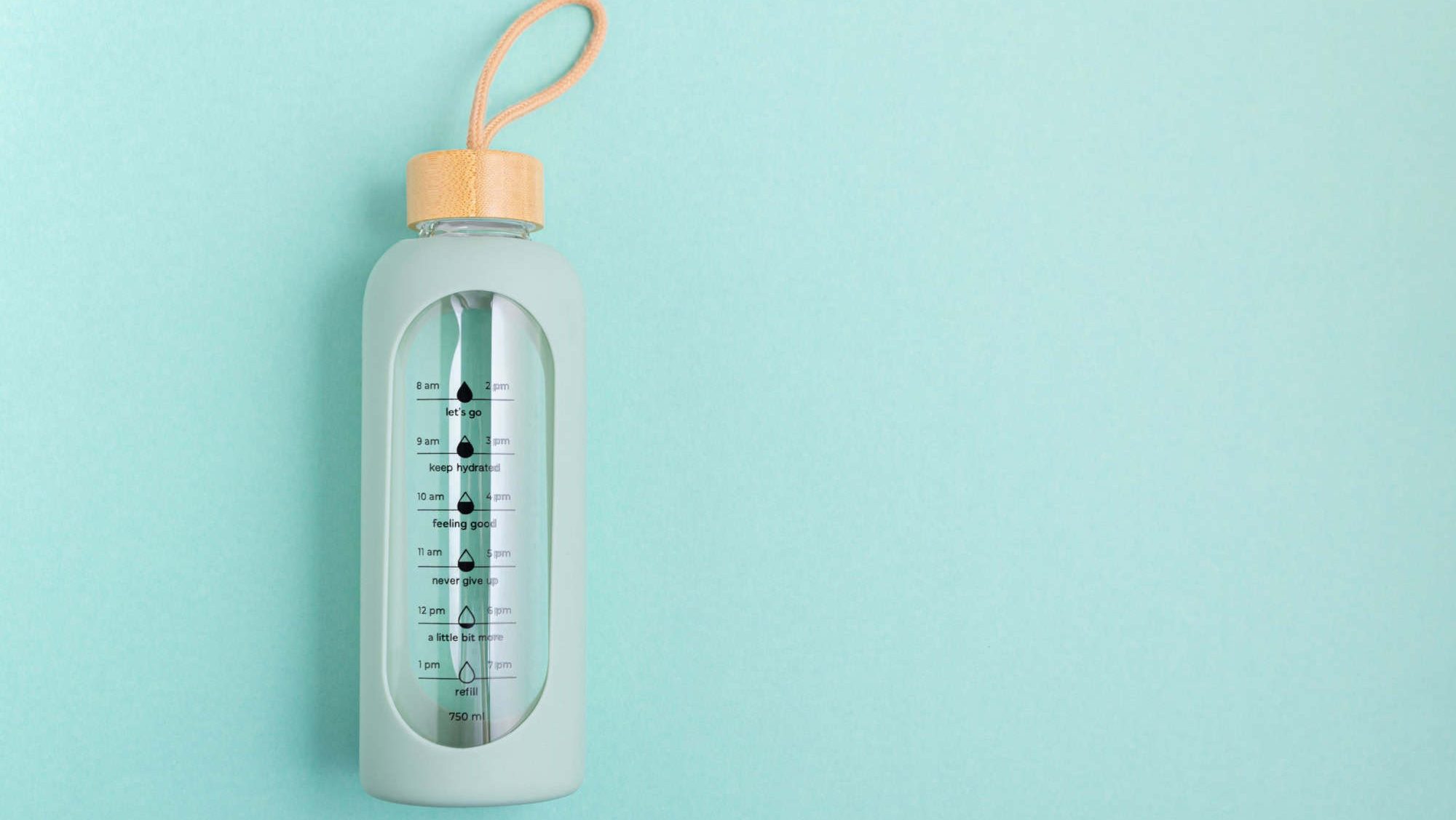 A glass water bottle with time markers on a blue background.