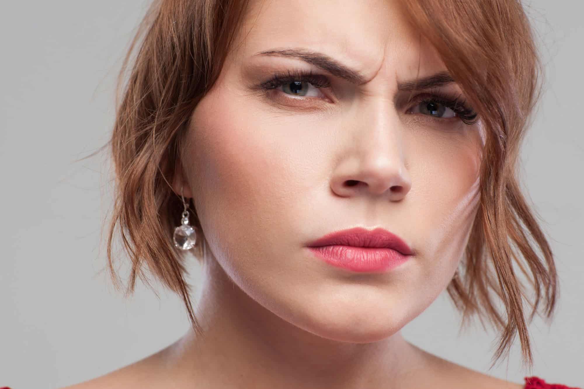 Suspicious look. Distrust in partner. Relationships problems, angry female portrait on grey background closeup, suspicion concept