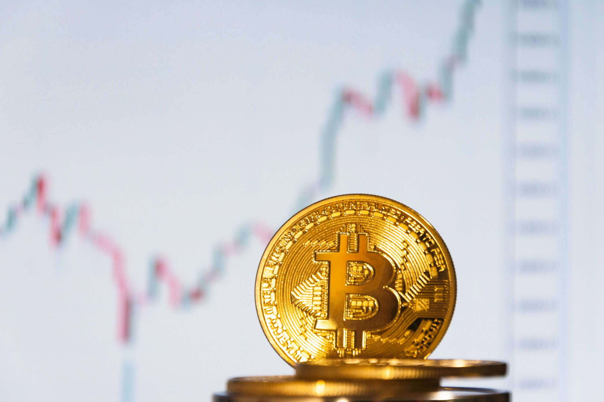Several coins of bitcoins lie on the keyboard. Bright glow, toning and blurring. The concept of crypto currency