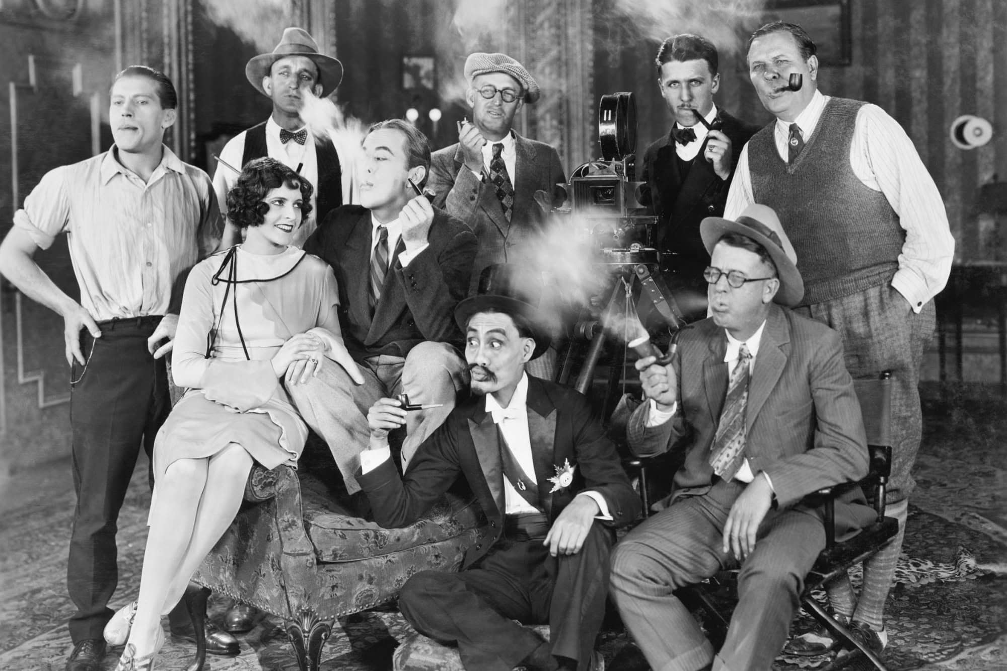 Group of people sitting in a living room smoking