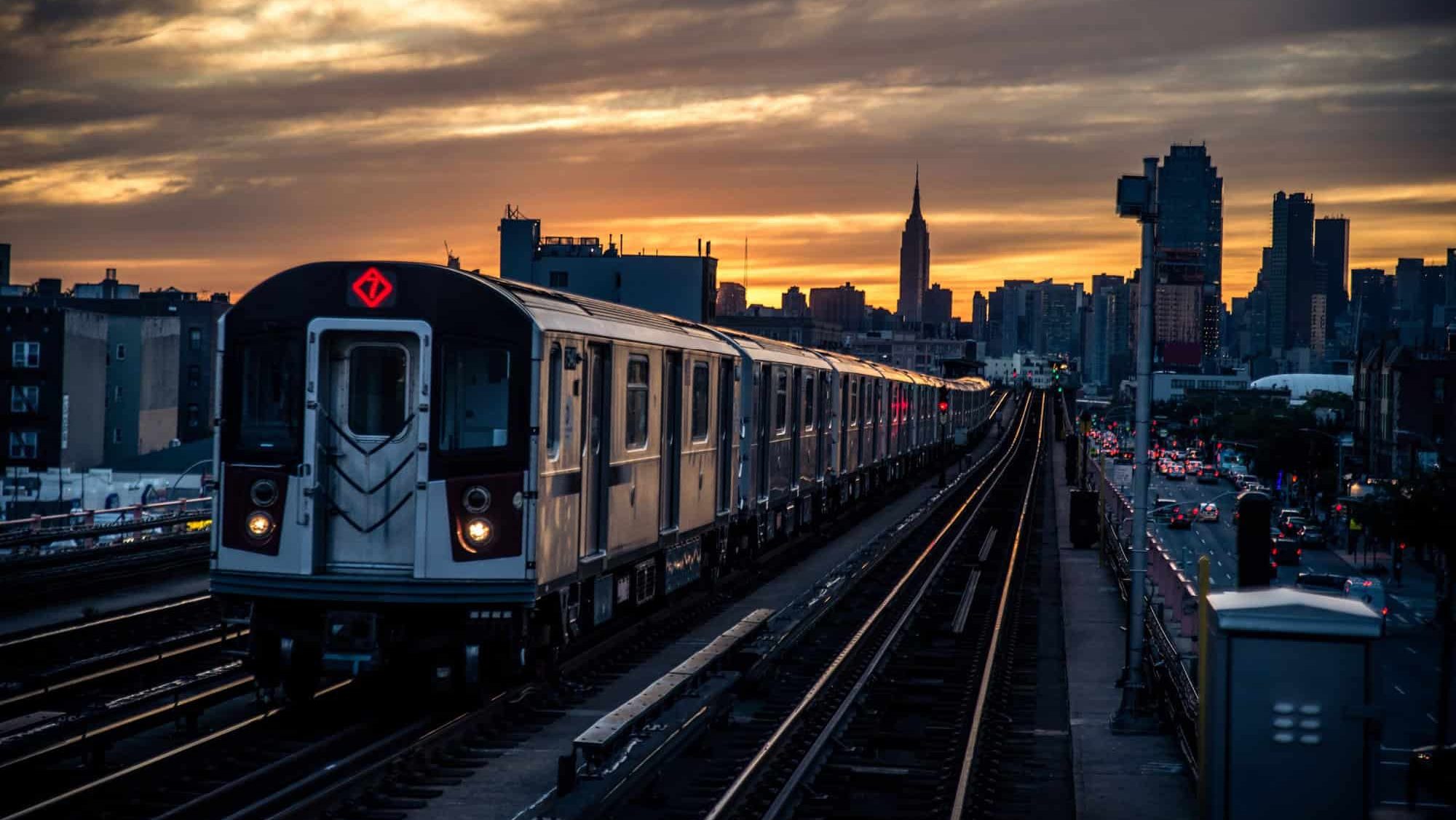Subway train in New York at sunset and Manhattan cityscape view