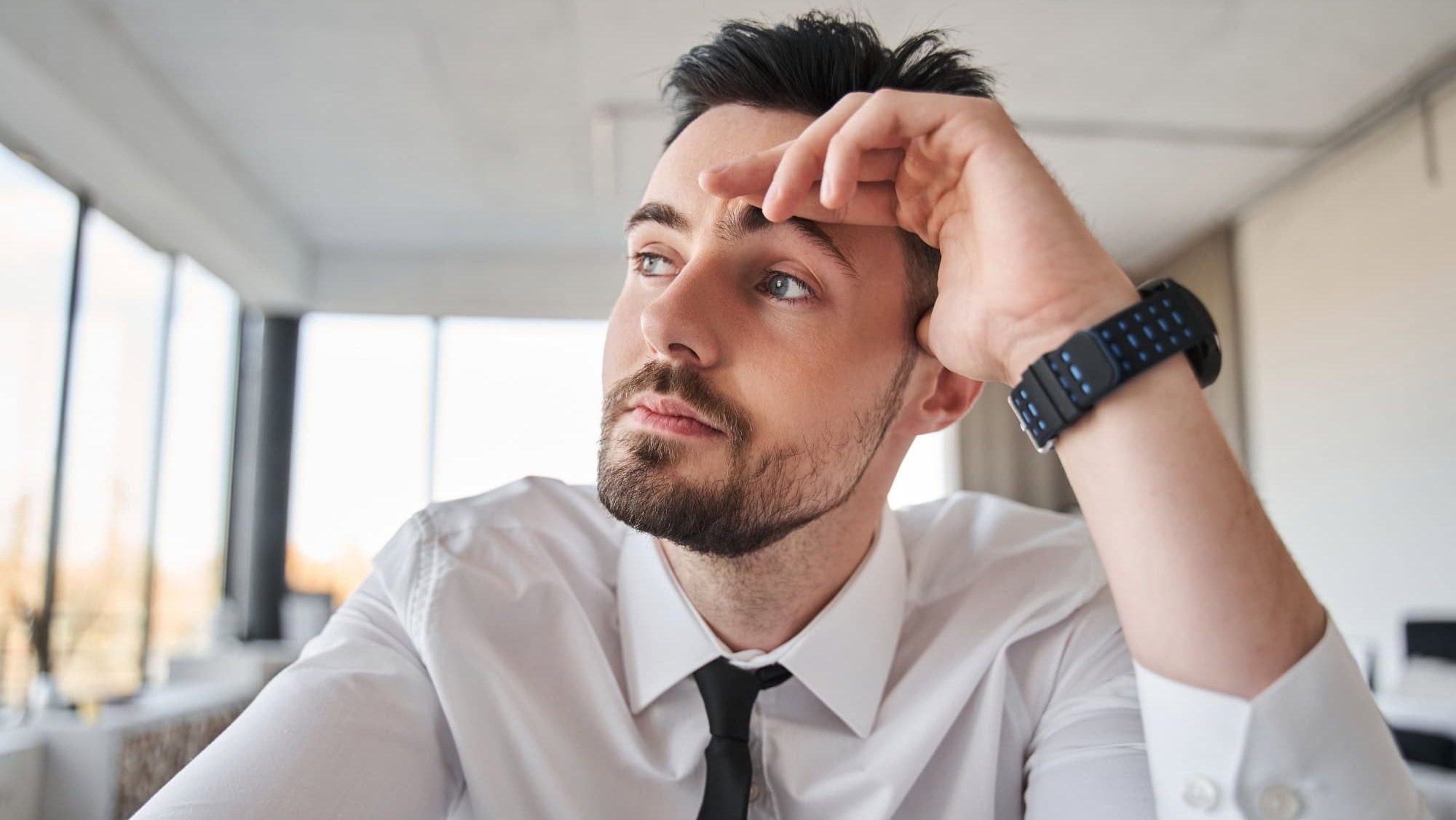 Manager or office worker looking away with mindful expression during online call