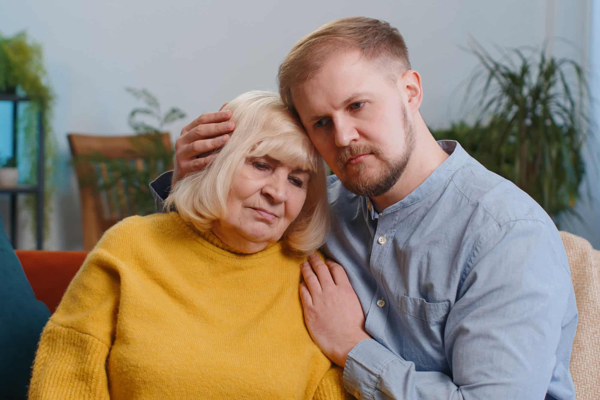 Adult man grandson supporting, giving psychological help to senior grandmother. Health problems, crisis, bankruptcy, debt, loan. Compassion. Son asking for apologizes to offended stressed elderly mom