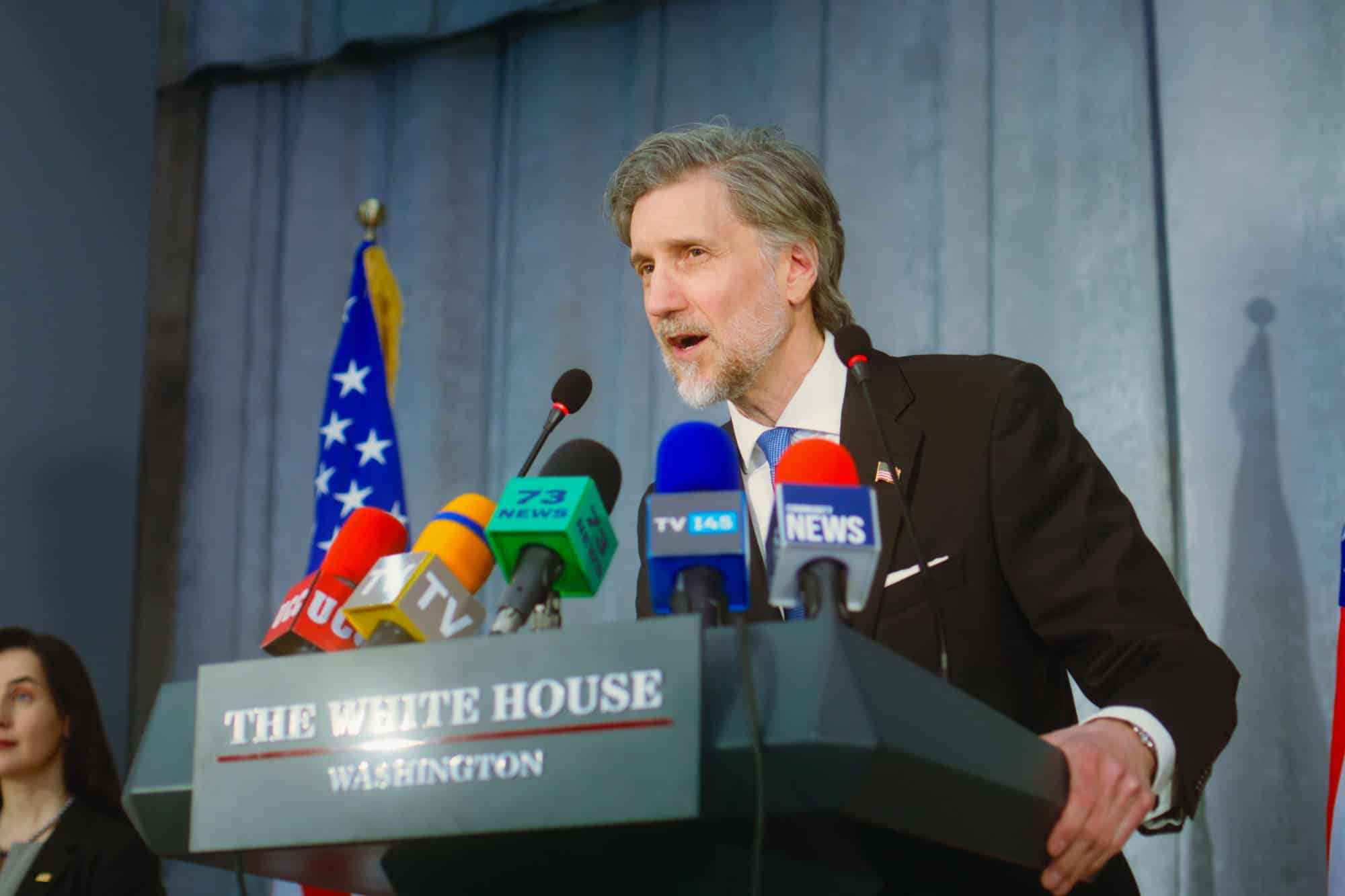 President of the United States says political speech from tribune, smiles and poses on cameras at press conference in the White House. American minister answers questions, gives interview for media.