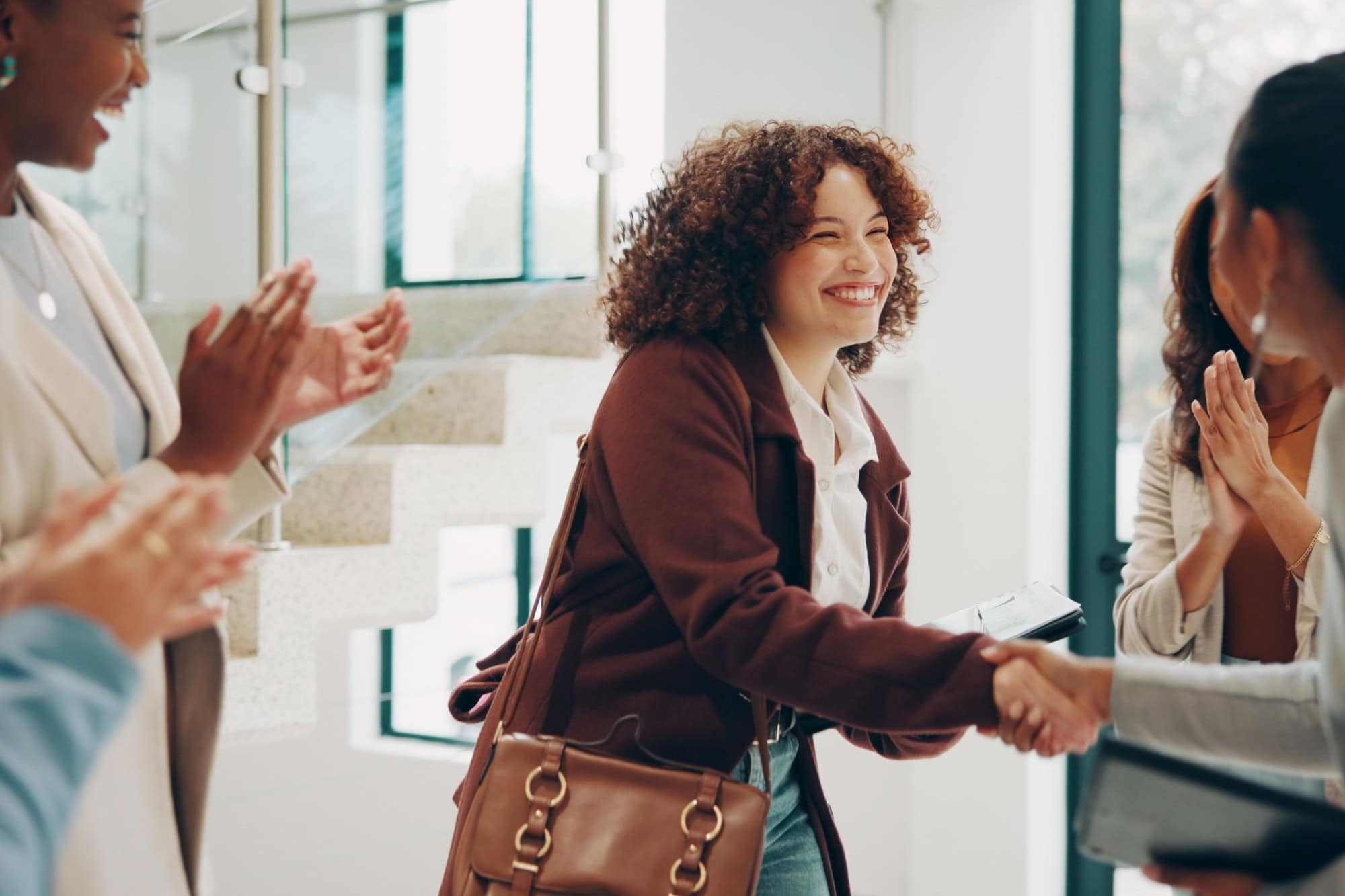 Employees, women and happy at office with handshake for recruitment, welcome and agreement. Business, people and smile or applause for job well done, promotion and career opportunity at meeting