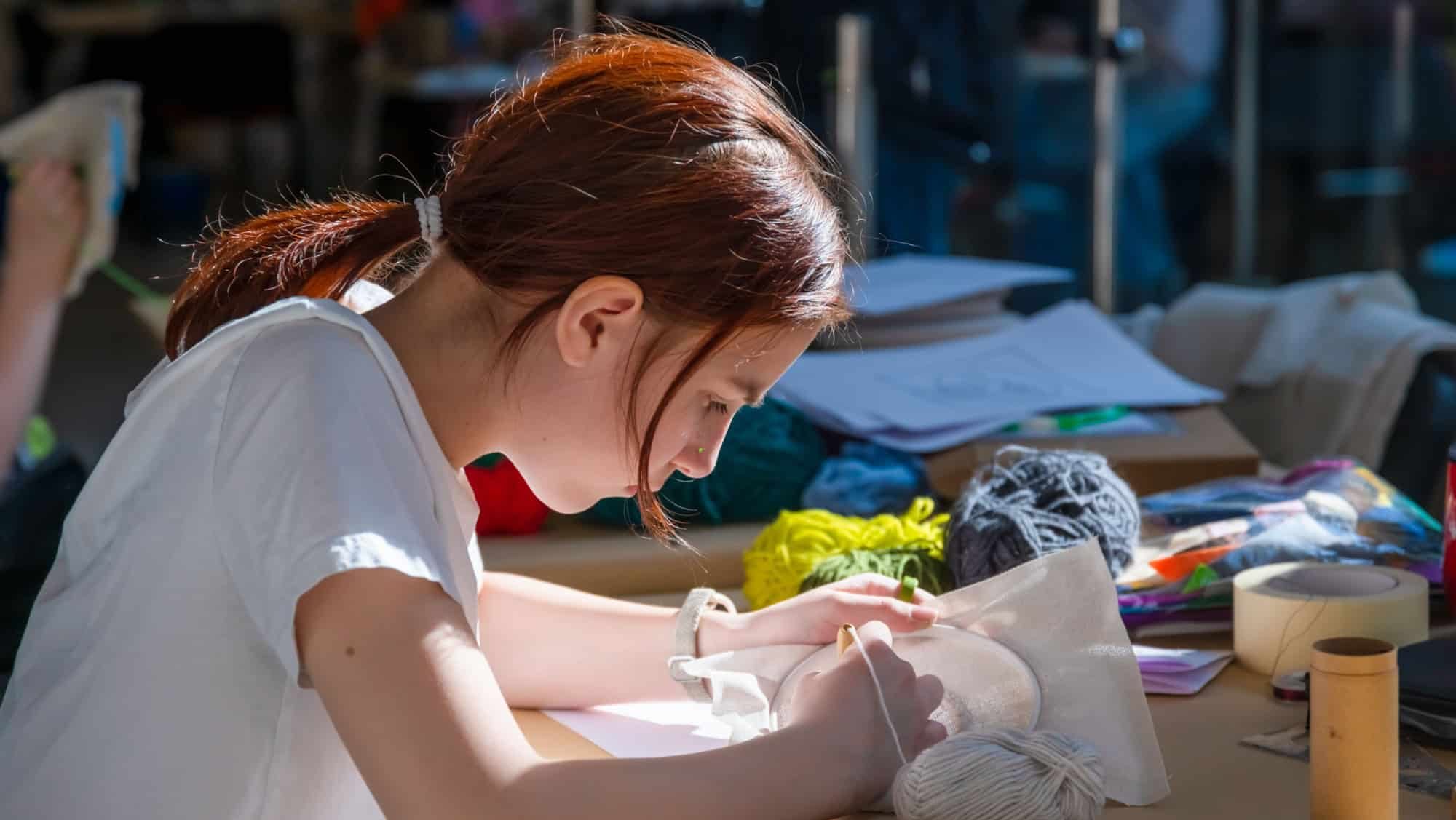 Teenage girl at carpet embroidery workshop, craft exhibition, craft fair, education, workshops, DIY