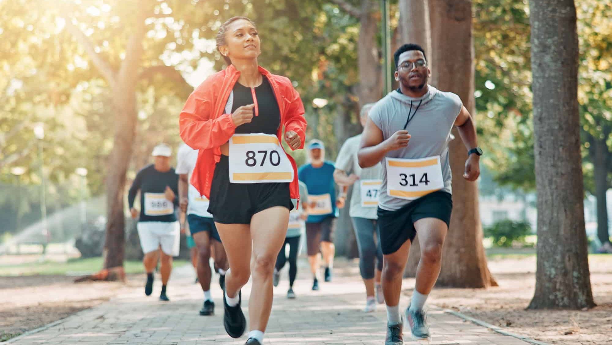 Running, marathon and speed with people in park for charity event, health challenge or fitness. Performance, fundraising competition and exercise with group of runners in nature for workout and sport