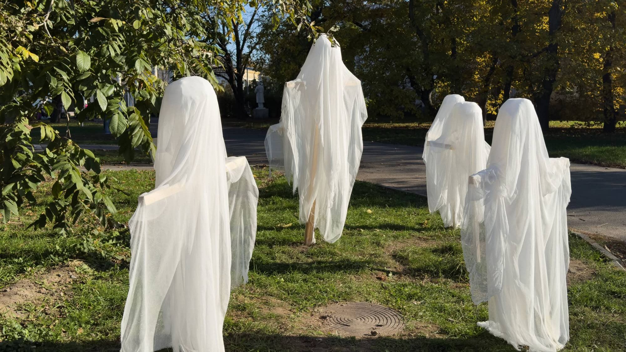 Scary white ghost figure in the garden. Halloween decorations
