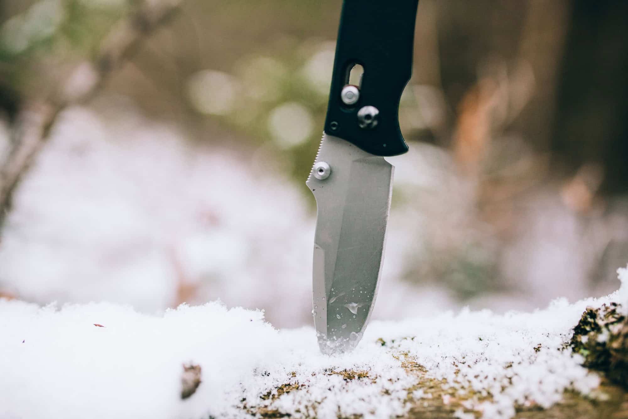 Sharp pocketknife in a snowy wood in winter