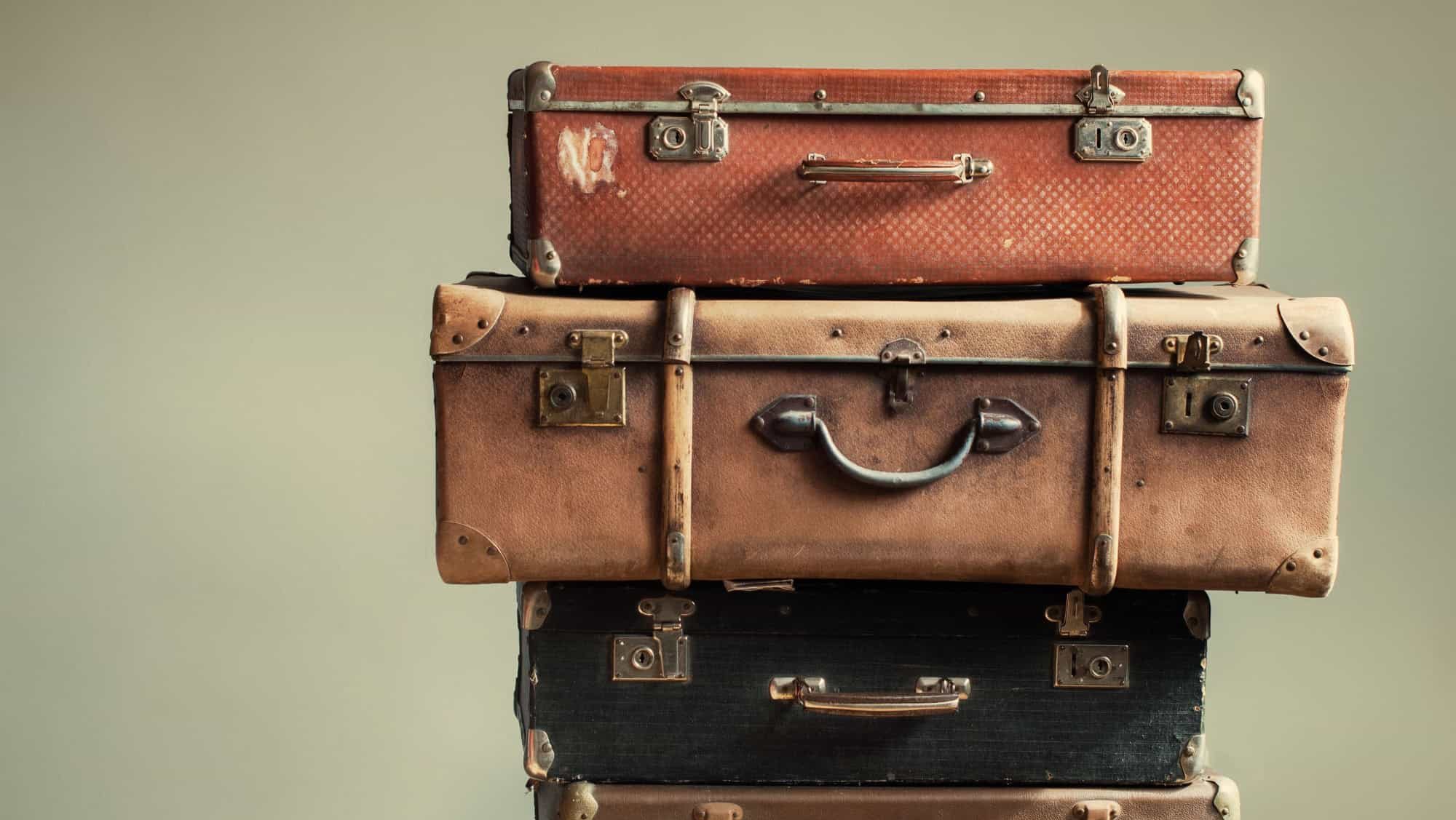Vintage Pile Ancient Suitcases Form of Tower Design Concept Travel Luggage Traveler on Shabby Beige Background