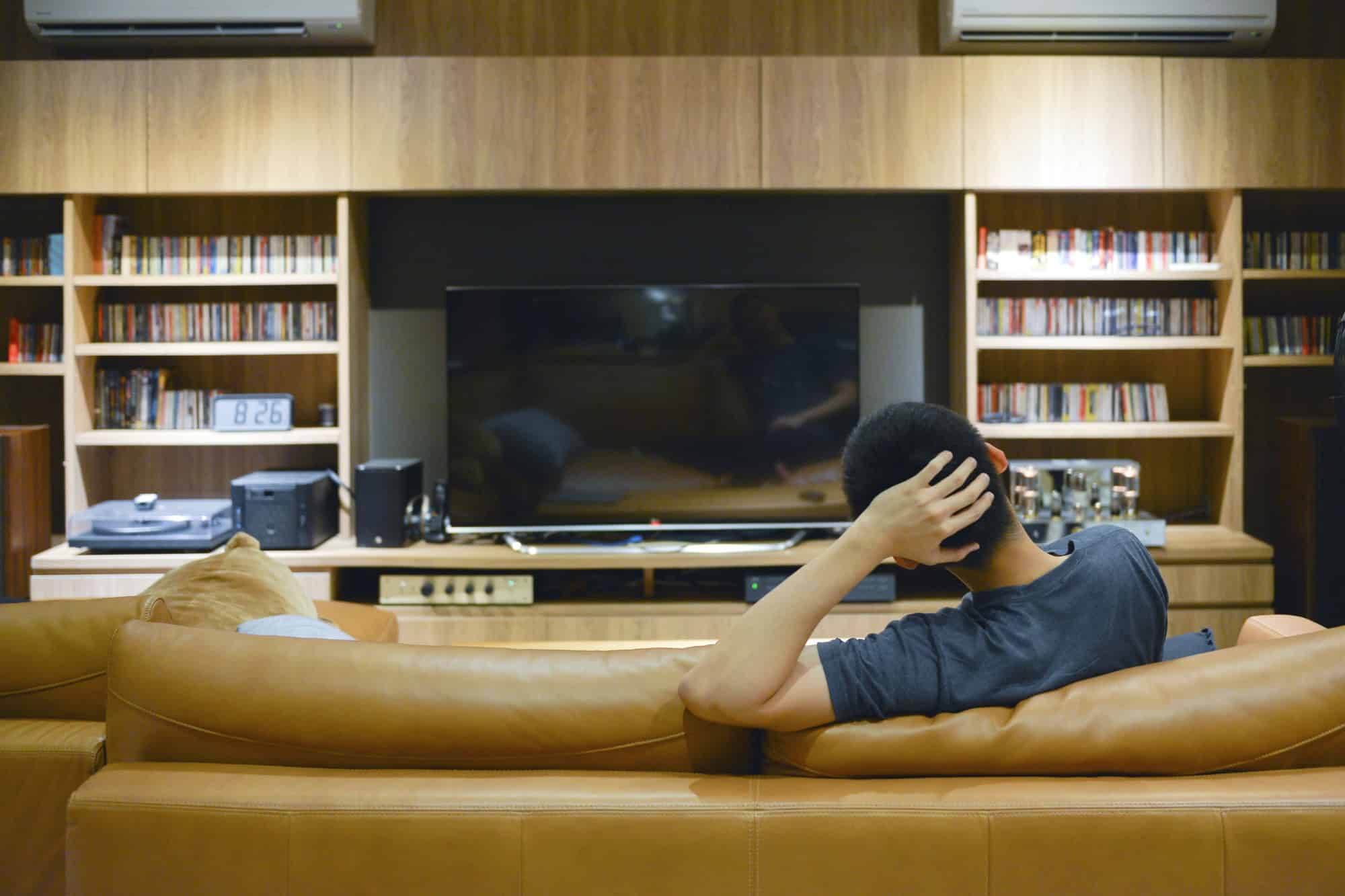Happy man watching a movie in living room at night