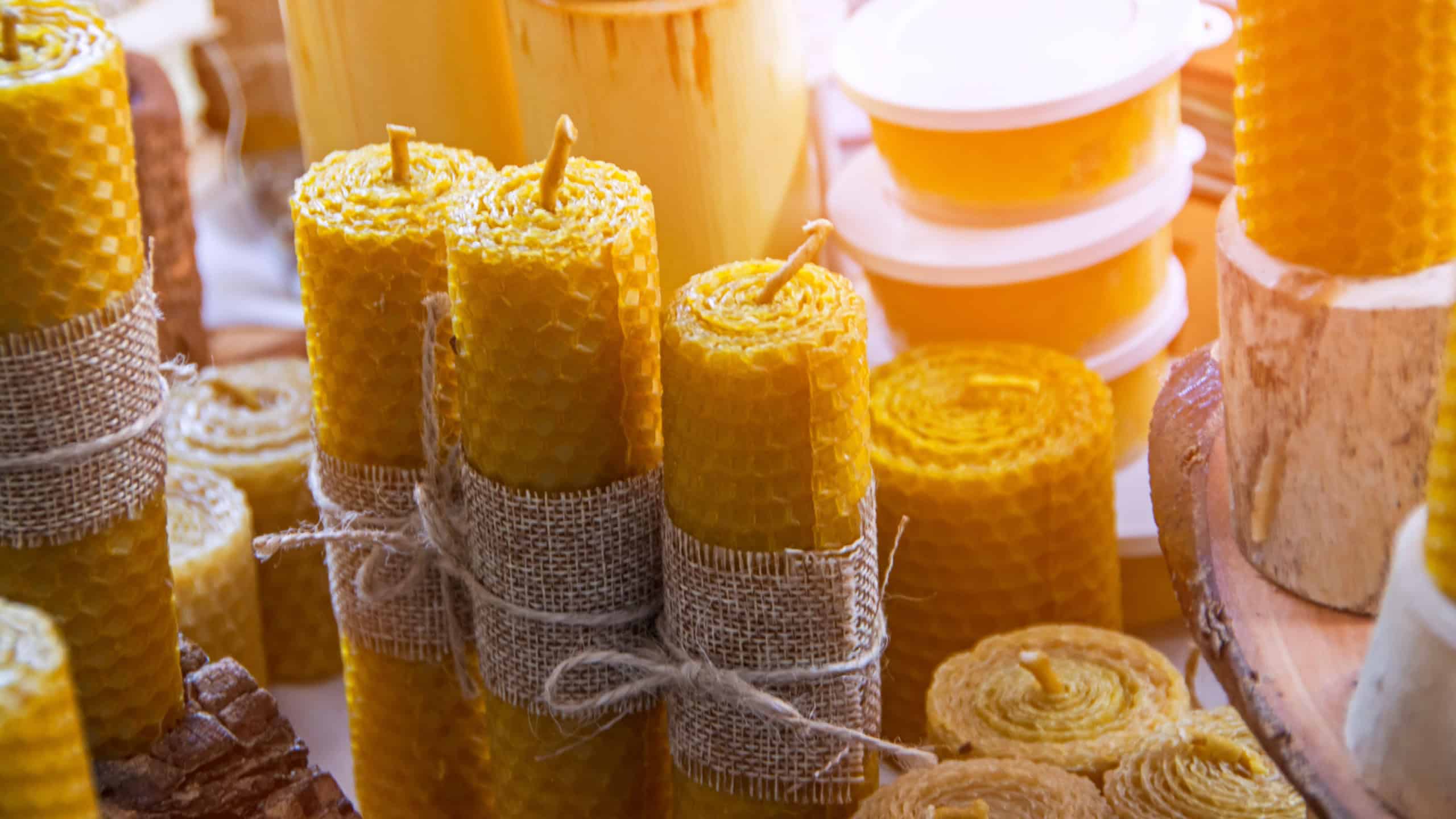 Beautiful hand made honey bee wax candles of different shapes lit by sunlight