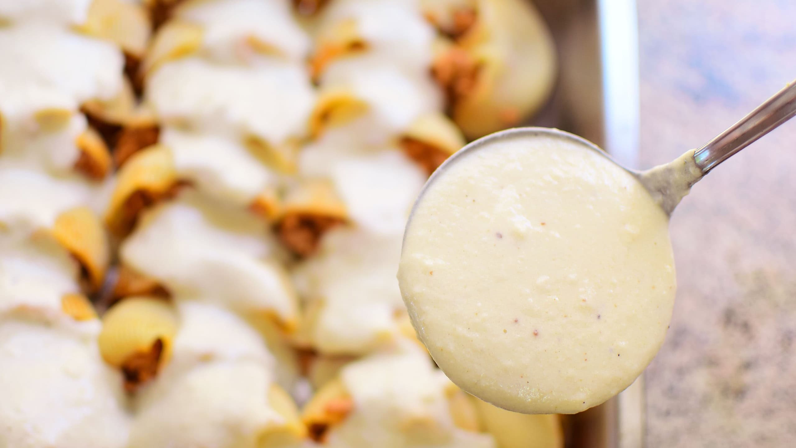 Preparation of homemade lumaconi filled in with tomato sauce and minced meat. Adding some cheese and béchamel sauce. Italian pasta recipe