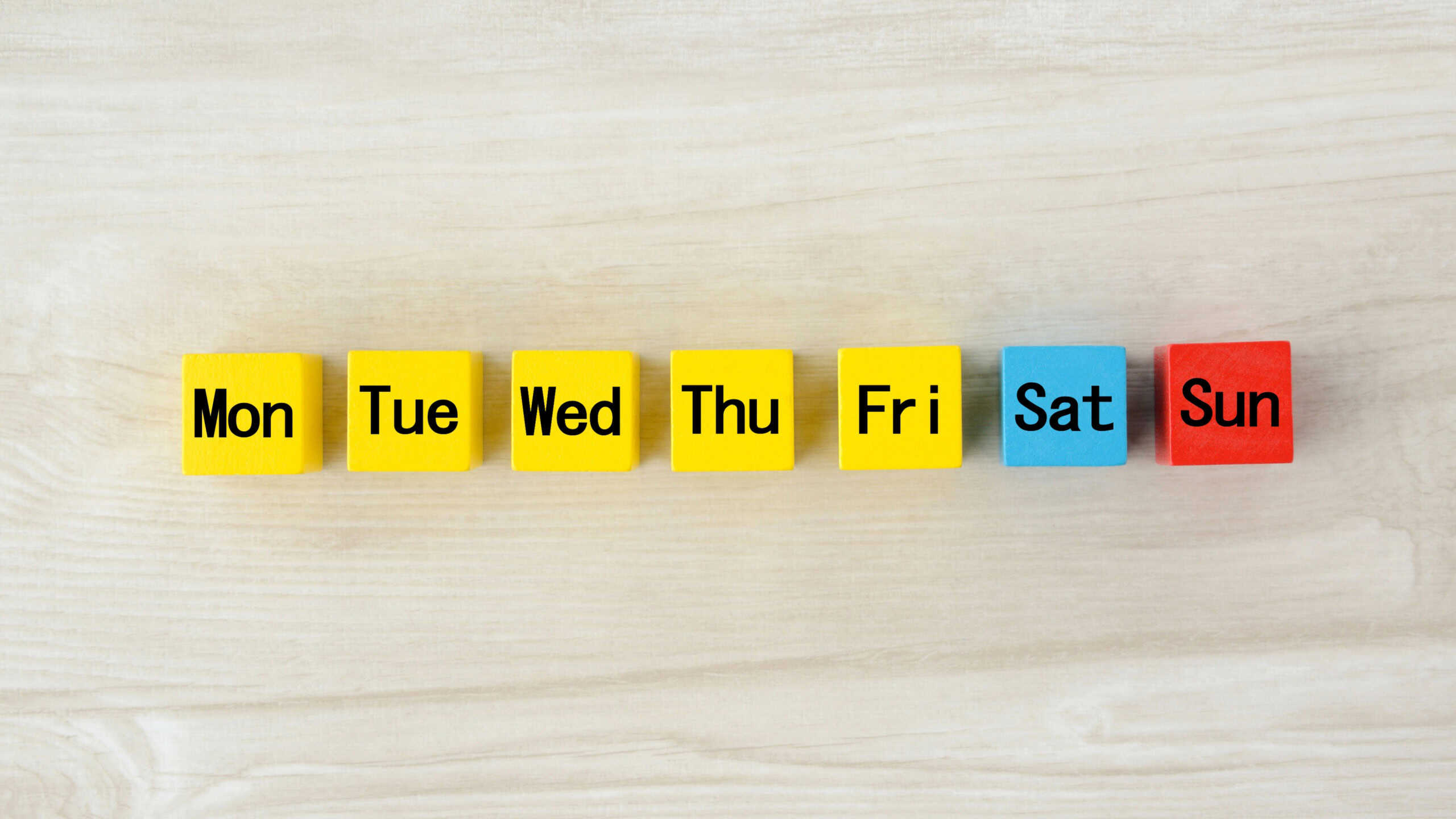 Colorful wooden blocks with omitted day of week words
