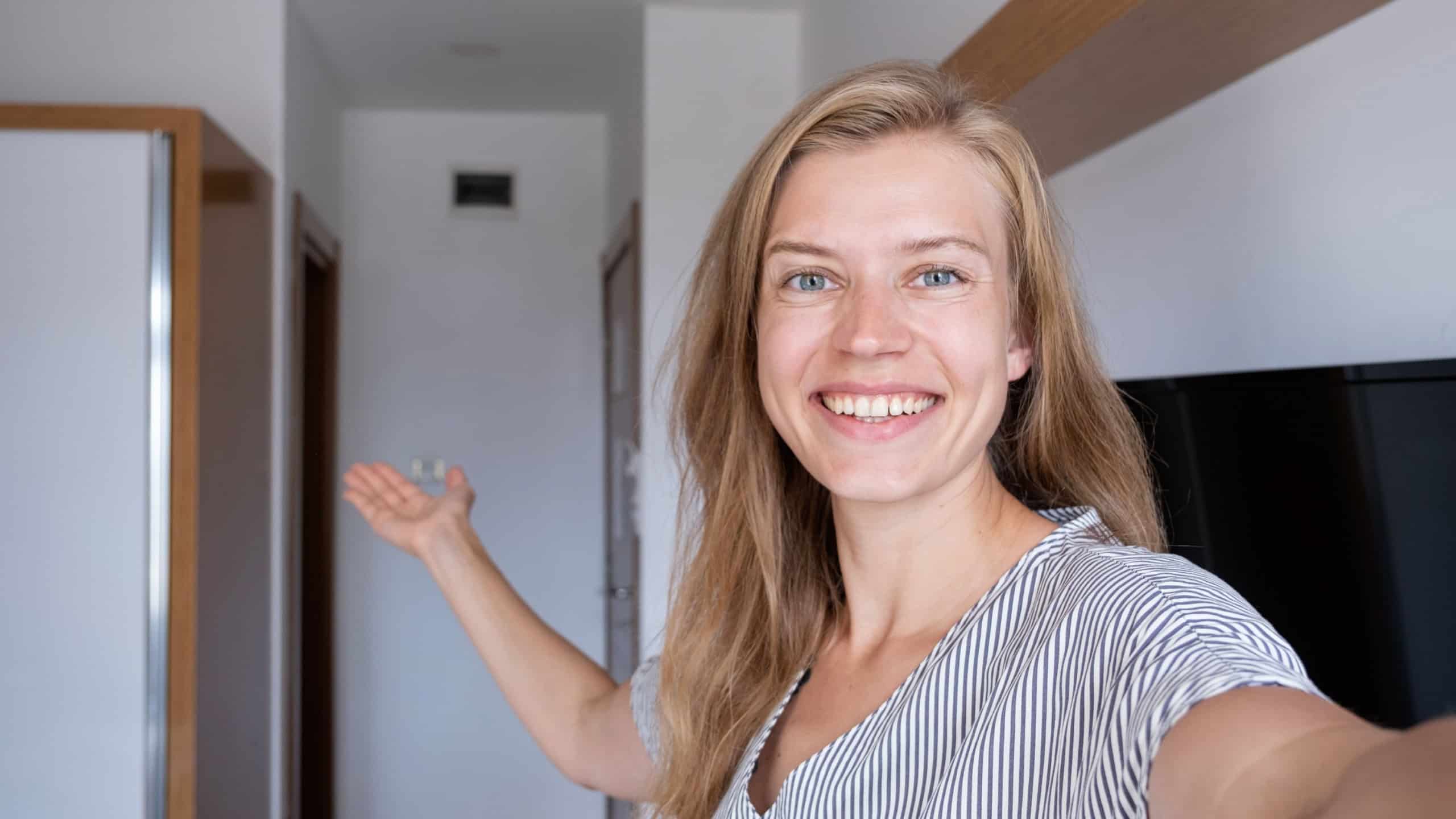 Vacation concept. Happy woman showing her hotel room taking selfie