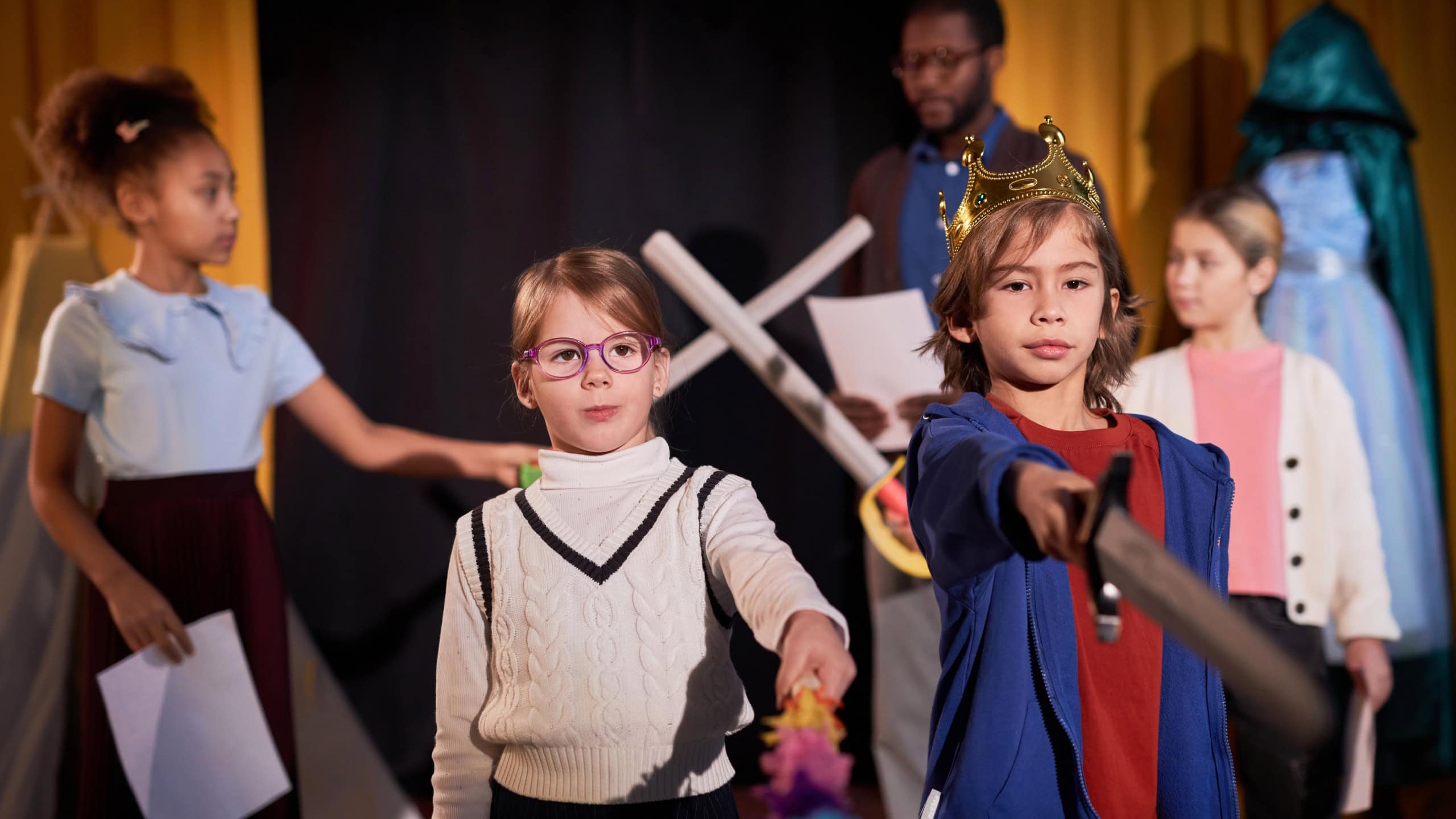 Waist up portrait of boy and girl standing on stage in theater and rehearsing school play copy space