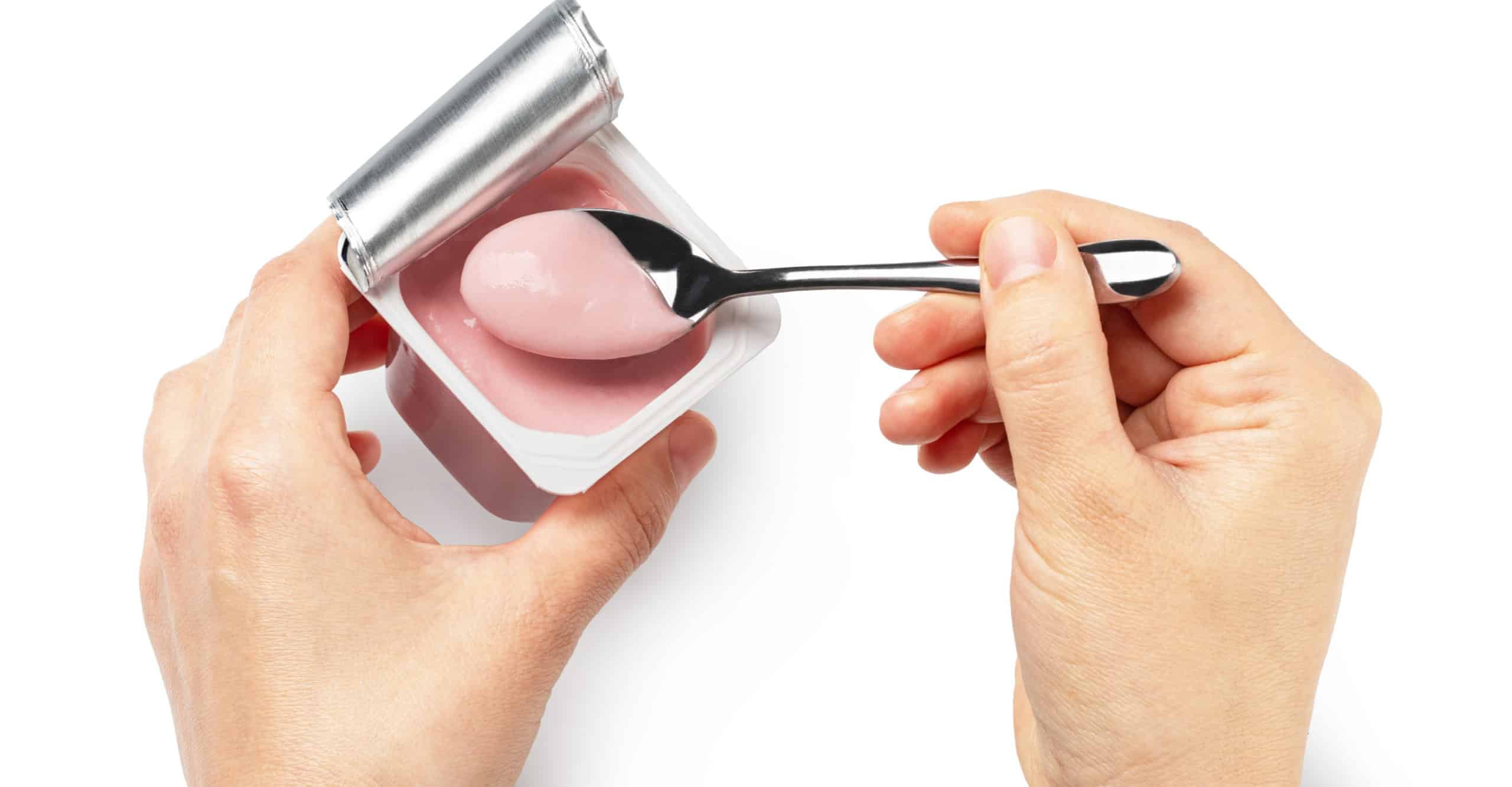 Woman holding a cup of yogurt isolated on white background