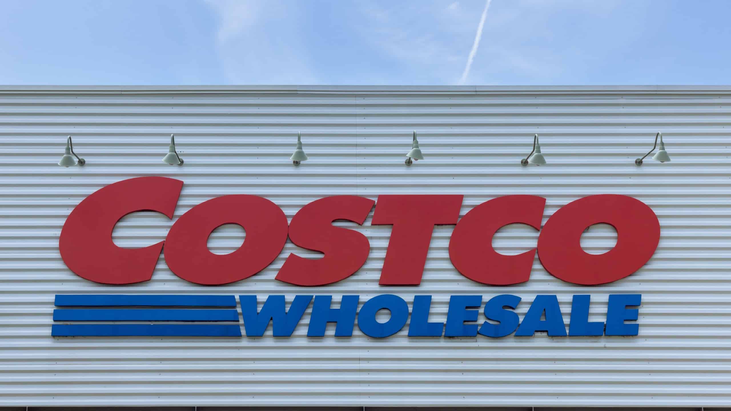 New York US Large Costco warehouse located in bustling suburban shopping area under bright sky
