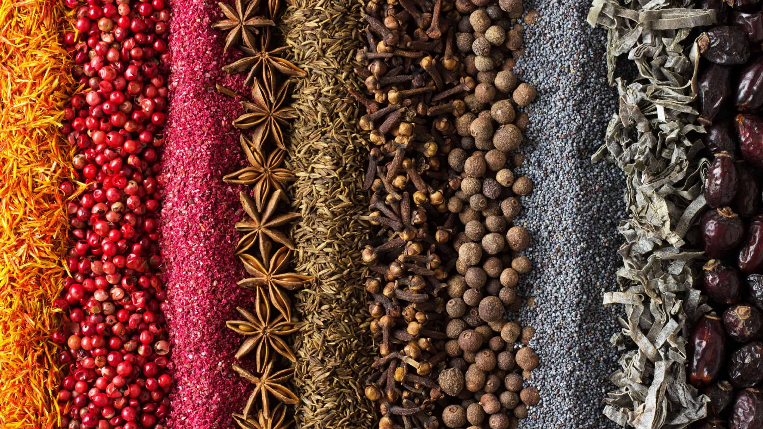 Spices and herbs background for website design. Seasonings scattered on the table.