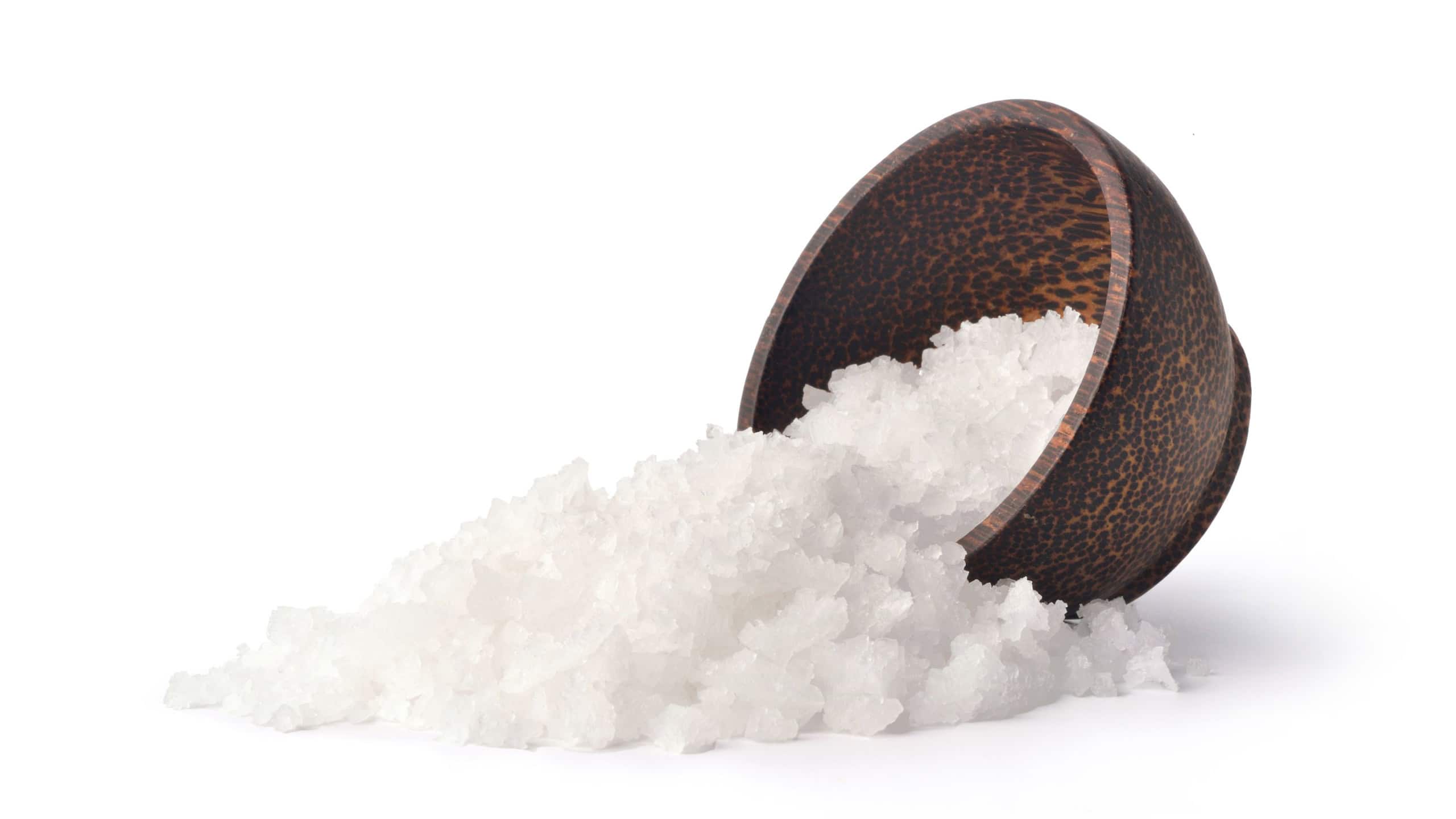 Pure natural sea salt in wooden bowl isolated on white background with clipping path.