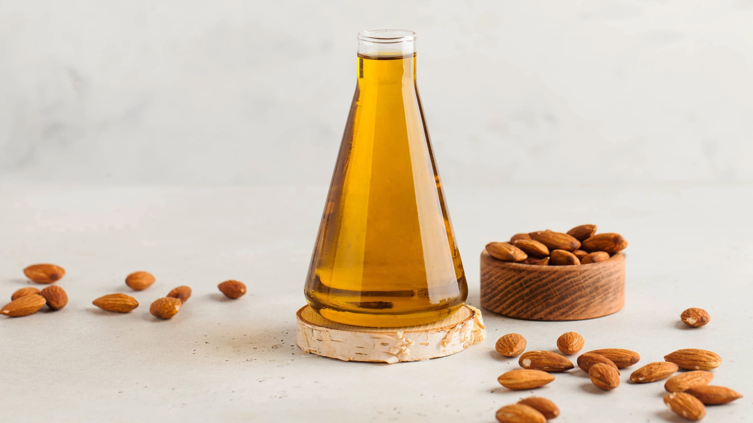 Banner Almond vegetable oil in a flask with almond nuts around. The concept of healthy eating. Copy space.