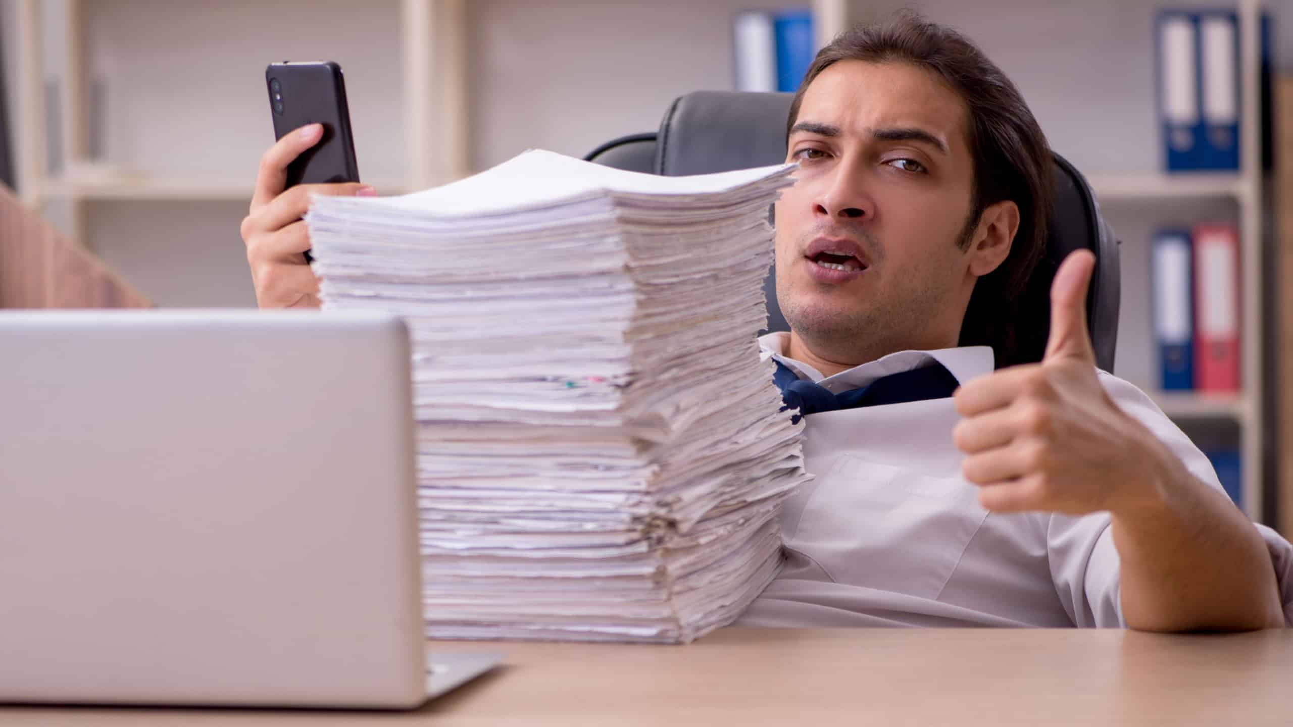 Young male employee unhappy with excessive work in the office