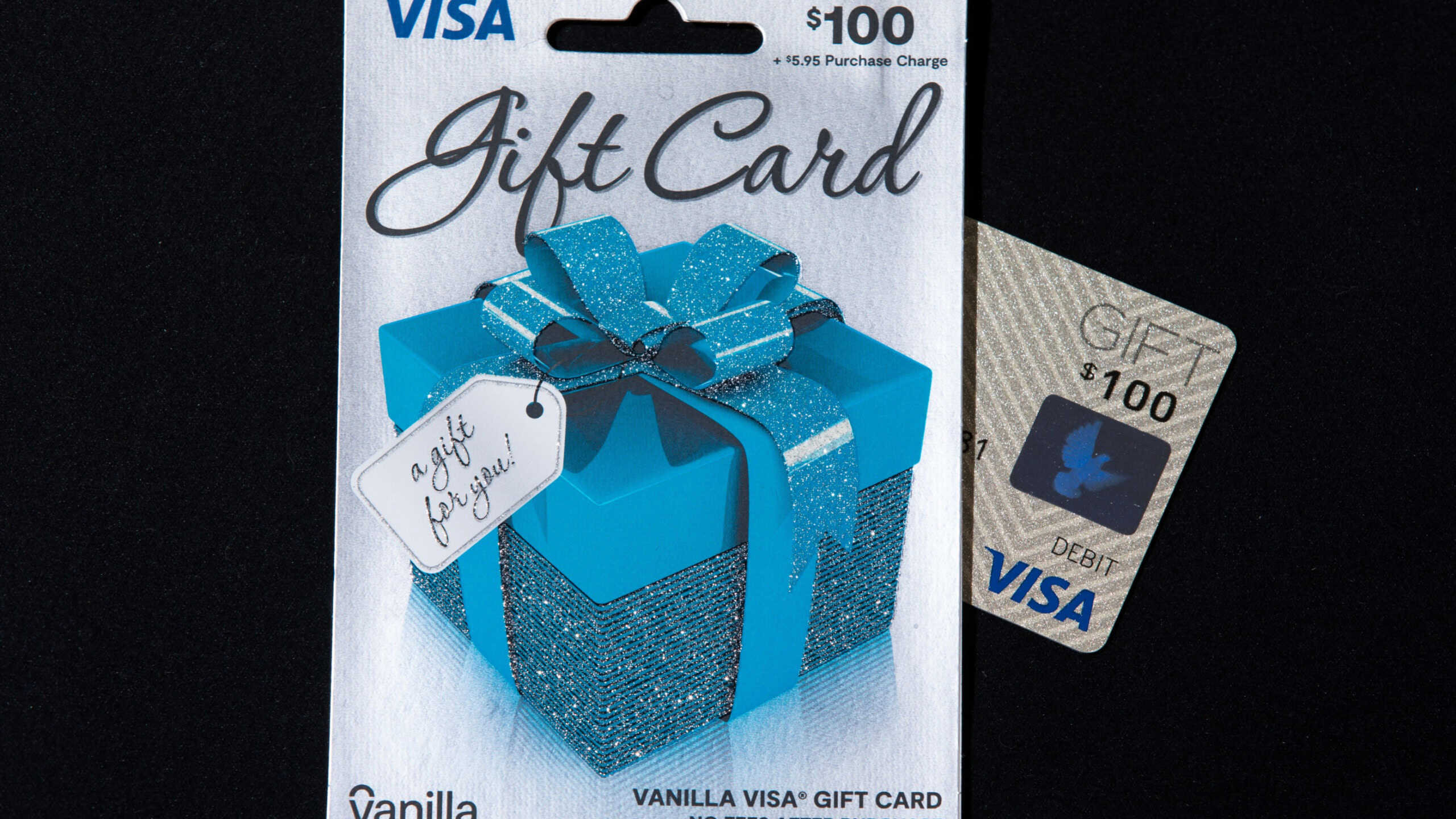 New York, NY, USA 8-9-2021: Vanilla Visa gift card with its envelope case. Blue present box with ribbon vector. $100 denomination before purchase fee. The text in cursive writes, “a gift for you!”
