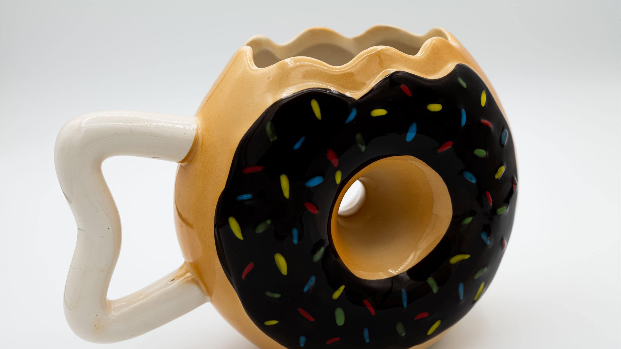 A close-up shot of a cute donut-shaped mug isolated on a white background