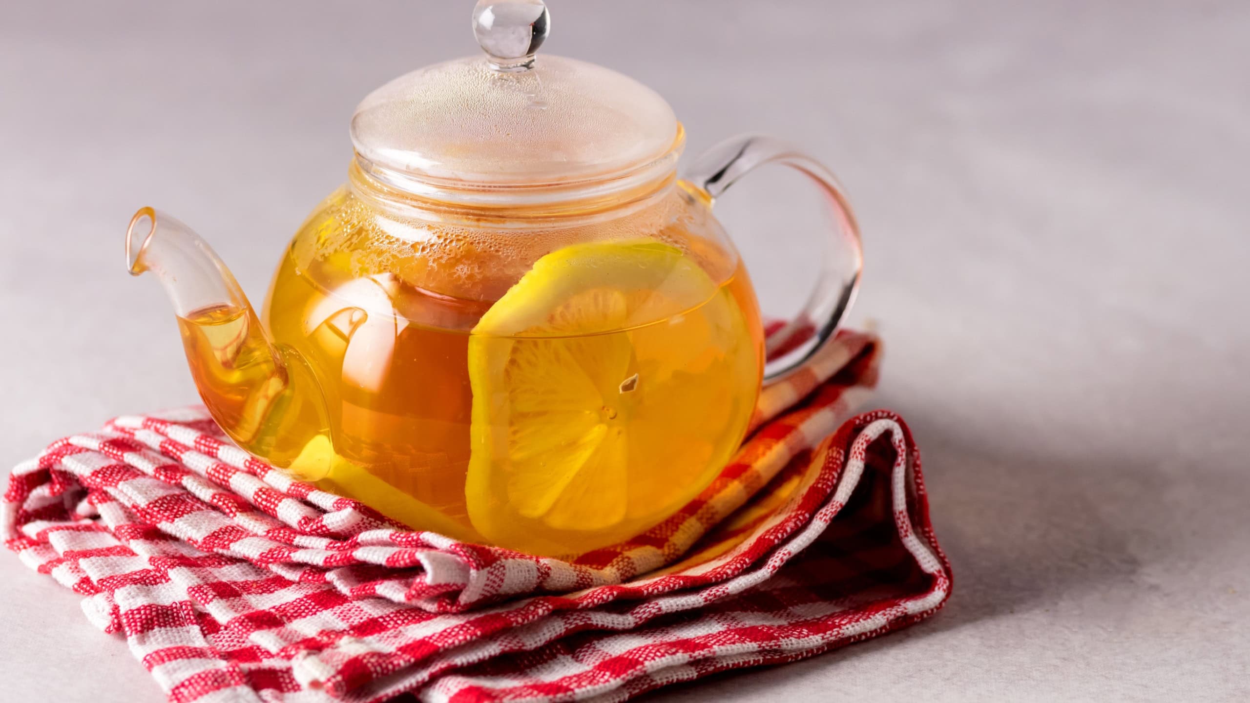 Hot Tea with Lemon in Teapot on Linen Napkin Glass Teapot with Healthy Drink for Cold and Flu Horizontal Copy Space