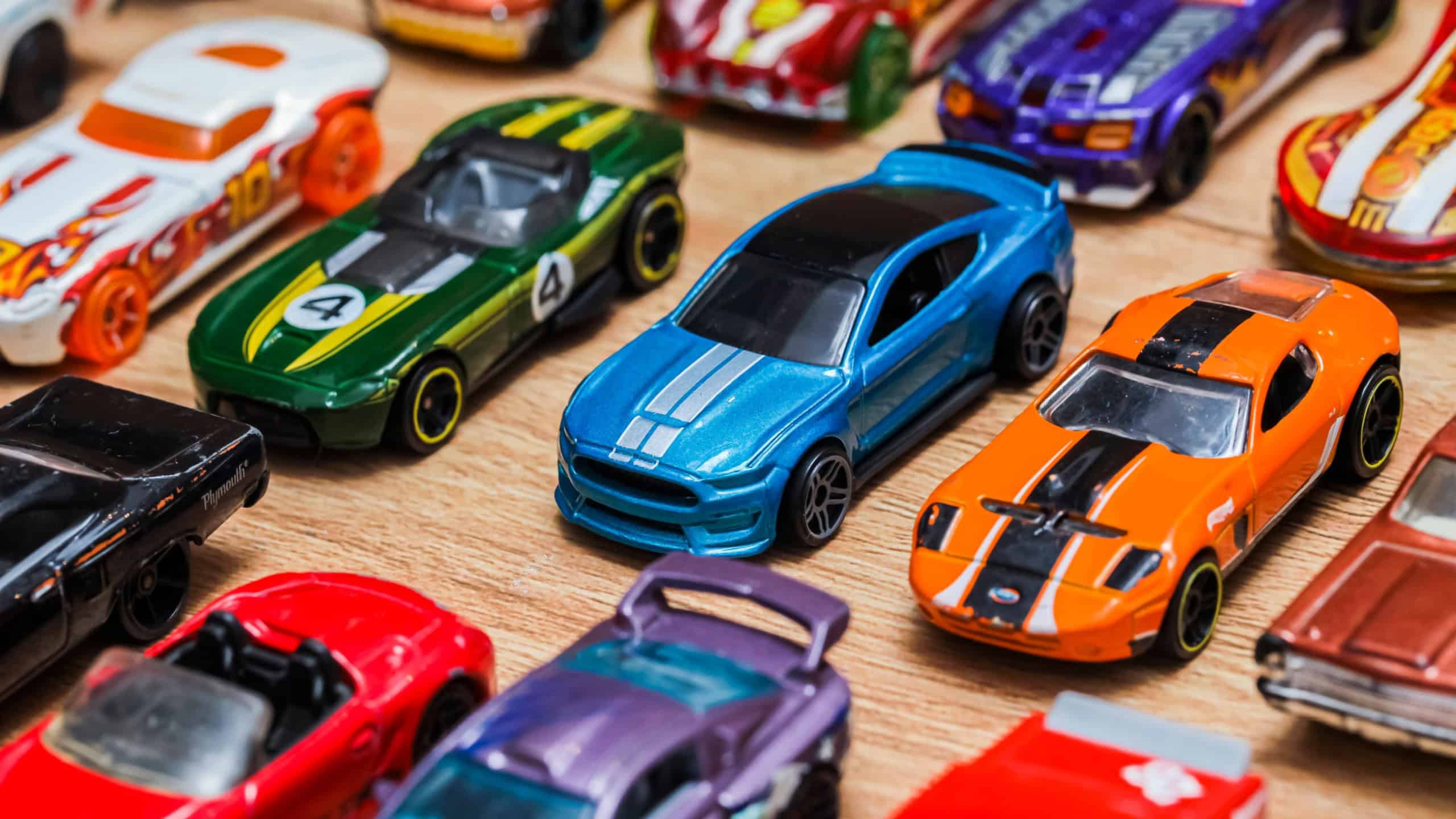 Bandung,Indonesia - 01-02-2023: The group of colorful toy car collection on wooden background. Hot Wheels. Top view. Selective focus.