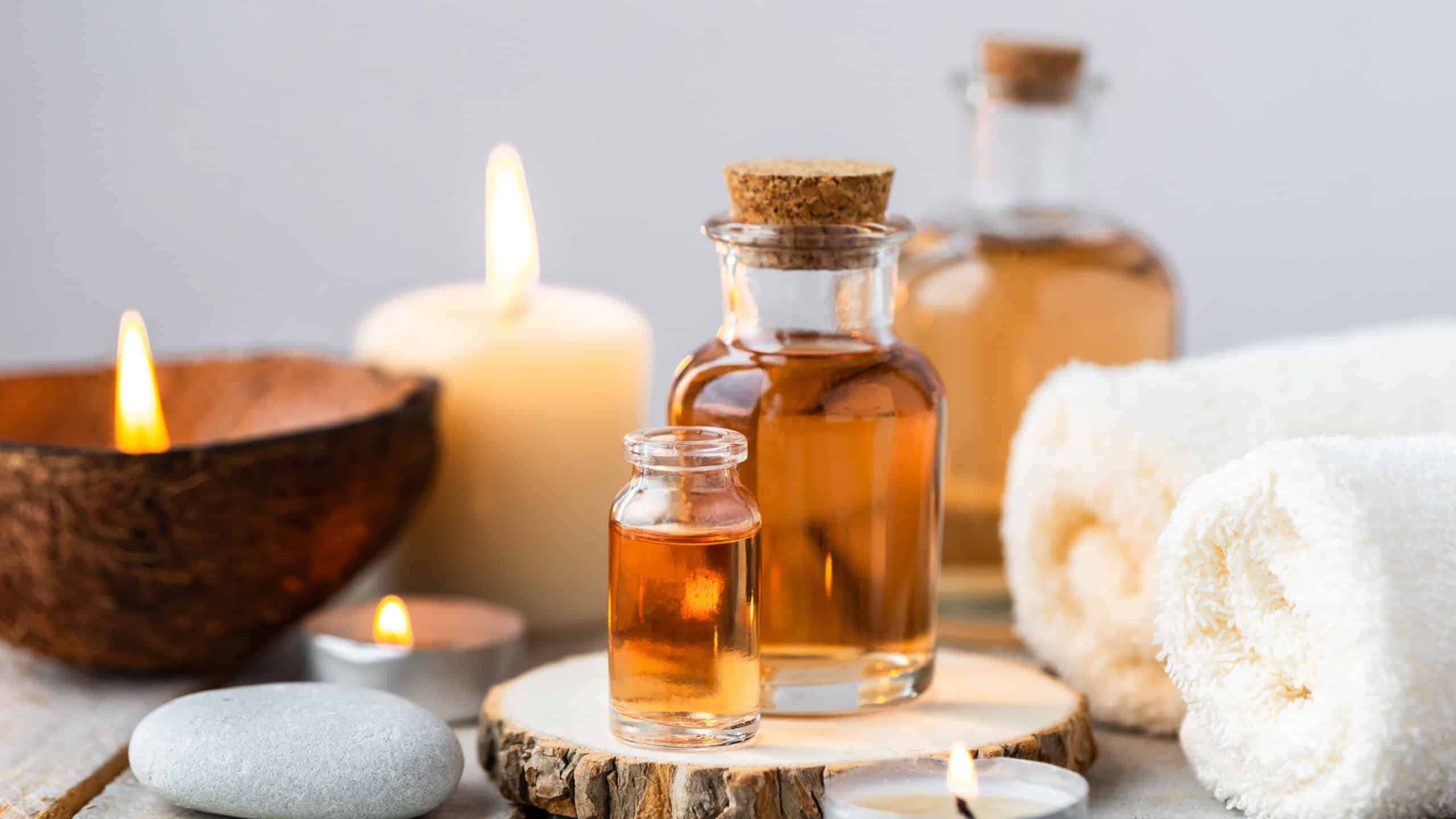 Concept of spa treatment in salon with pure organic natural oil. Atmosphere of relax, detention. Aromatherapy, candles, towel, wooden background. Skin care, body gentle treatment