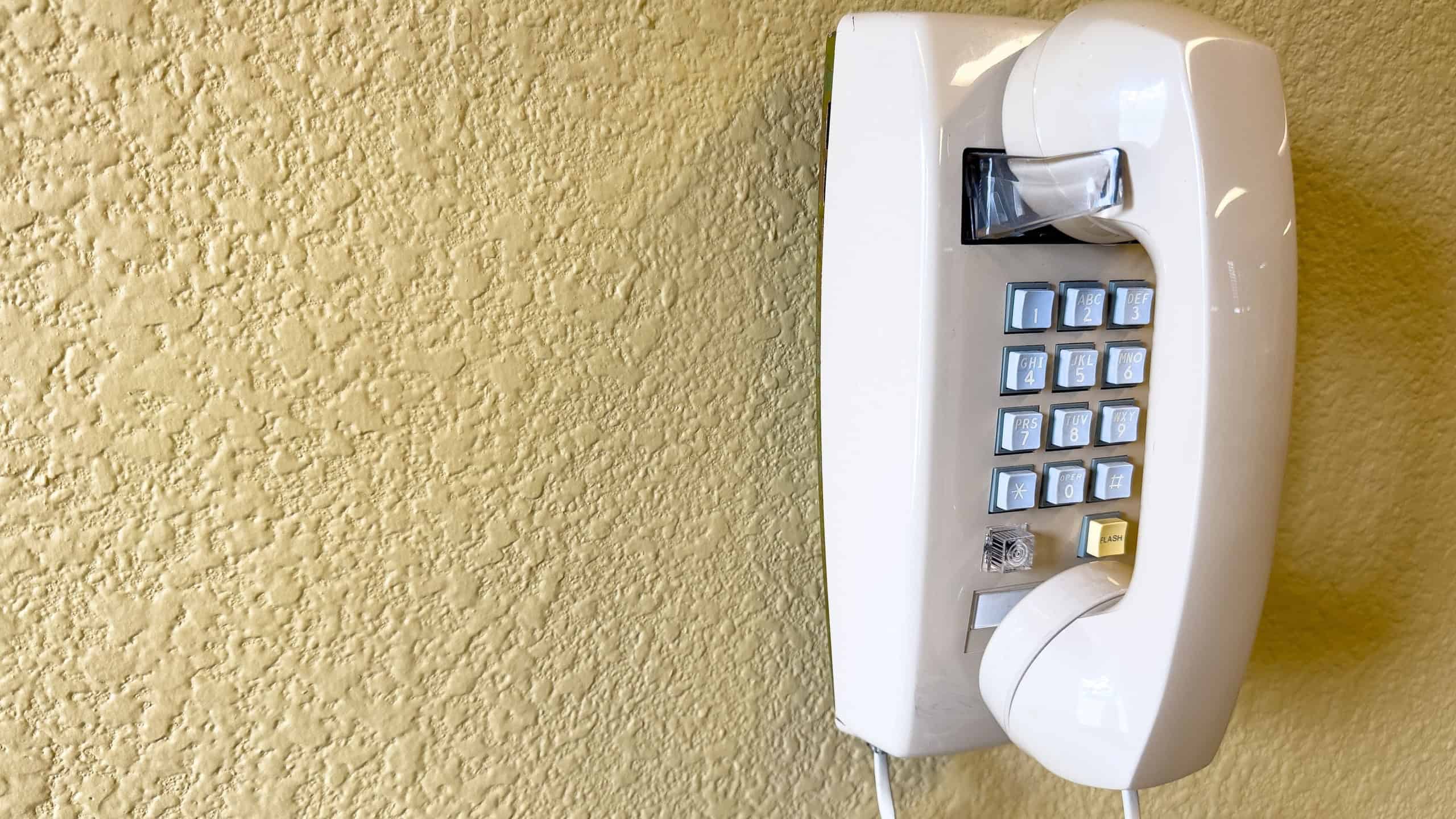 San Jose, CA - March 12, 2023: Wall mounted land line phone with a cord, copy space composed.