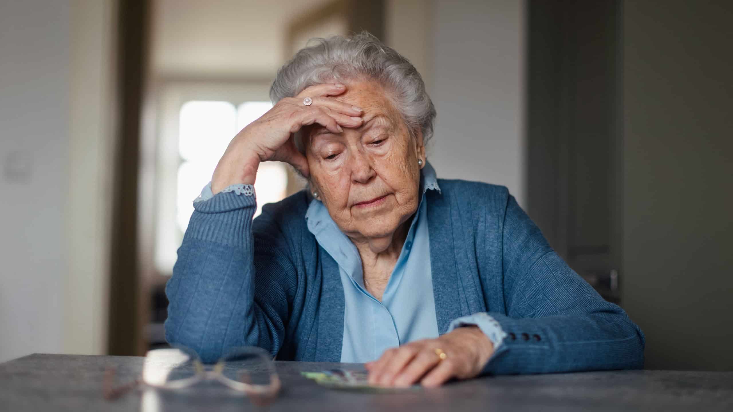 Senior woman counting her money at home.