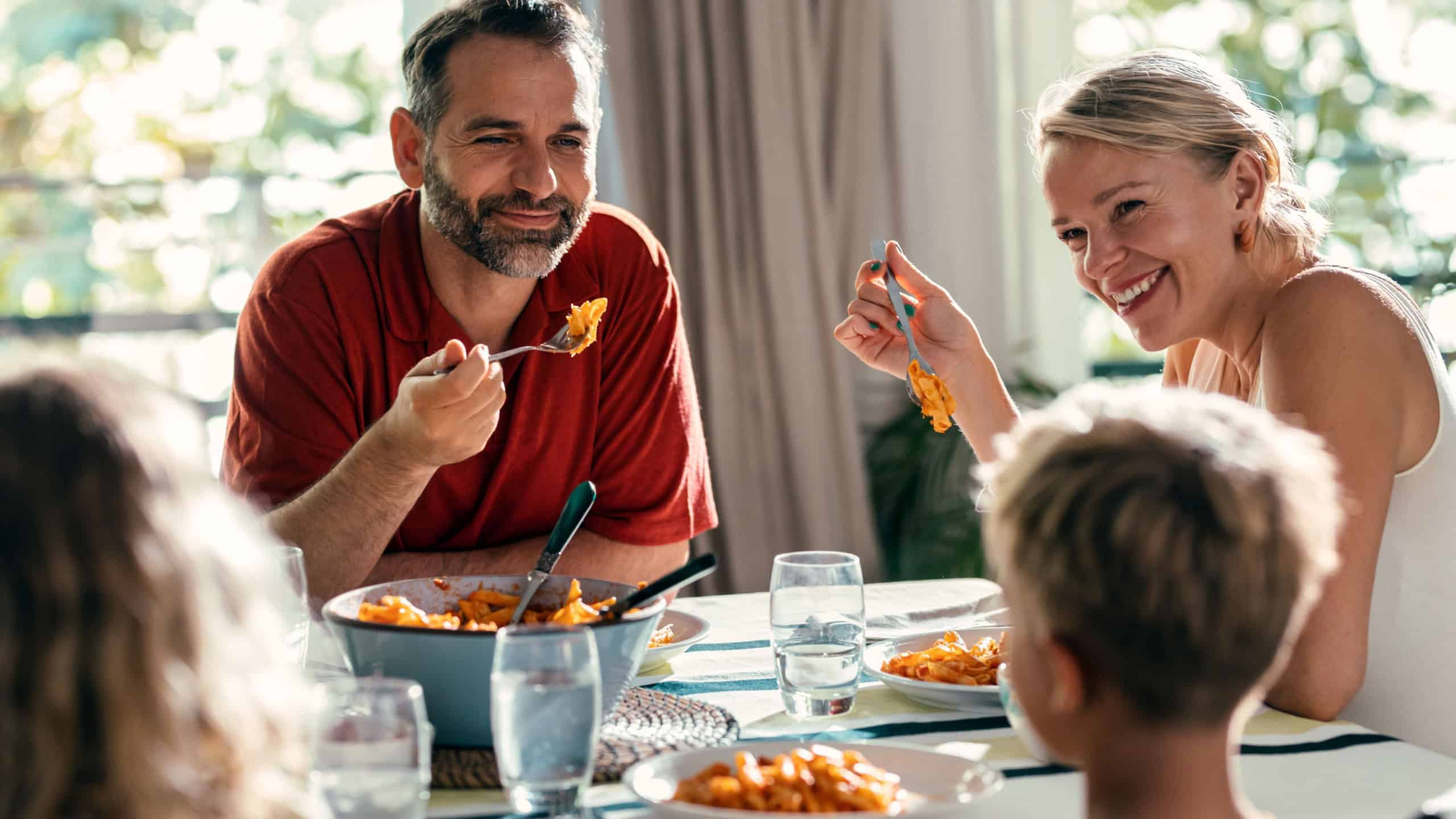 Shot of beautiful kind family talking while eating together in the kitchen at home