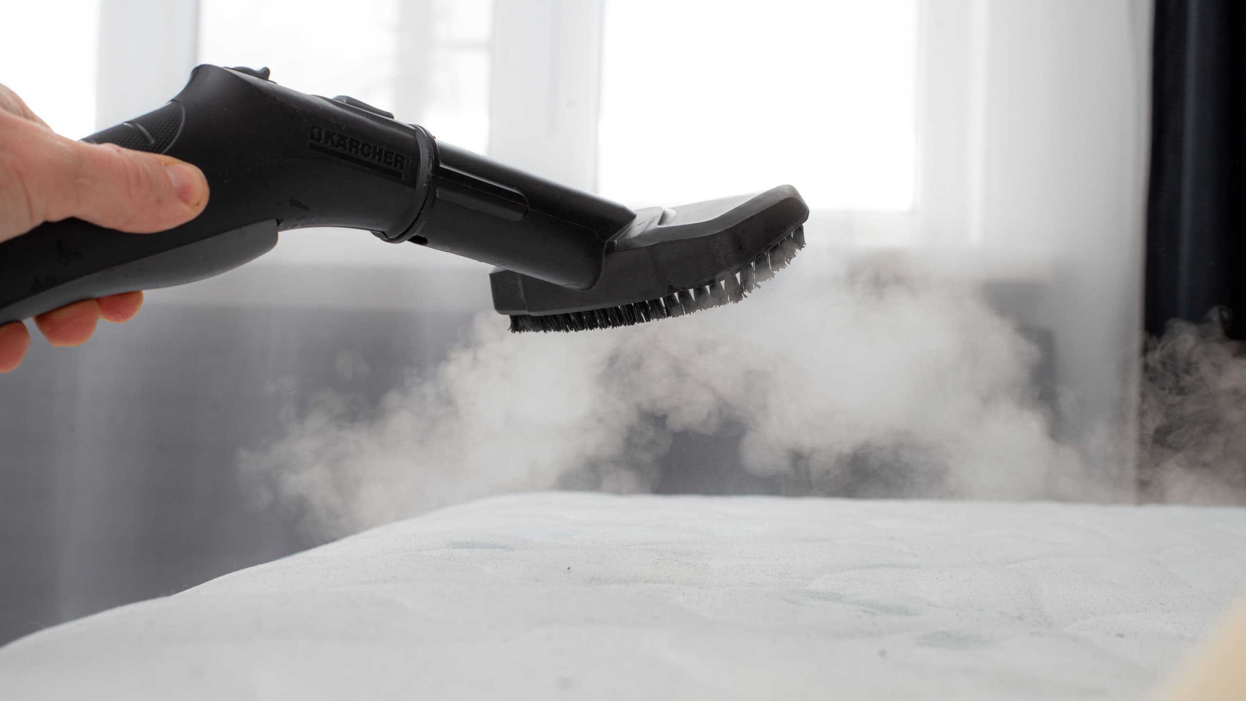cleaning mattress with professional equipment in bedroom, closeup