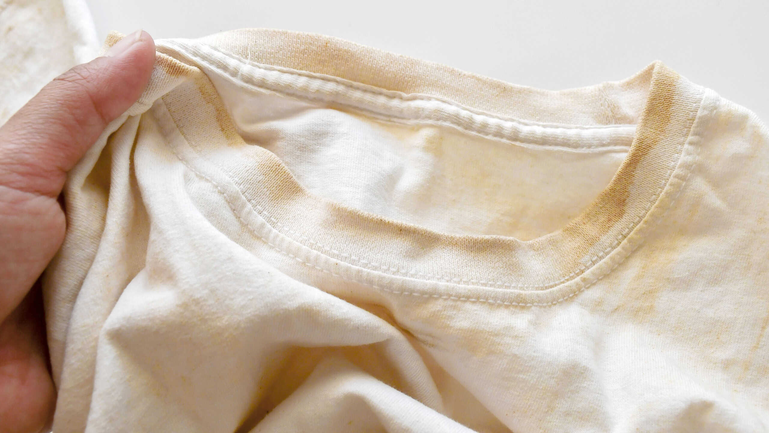 Dirty clothes with yellow stain on it. The concept of how to remove deep stains from clothes or fabric.