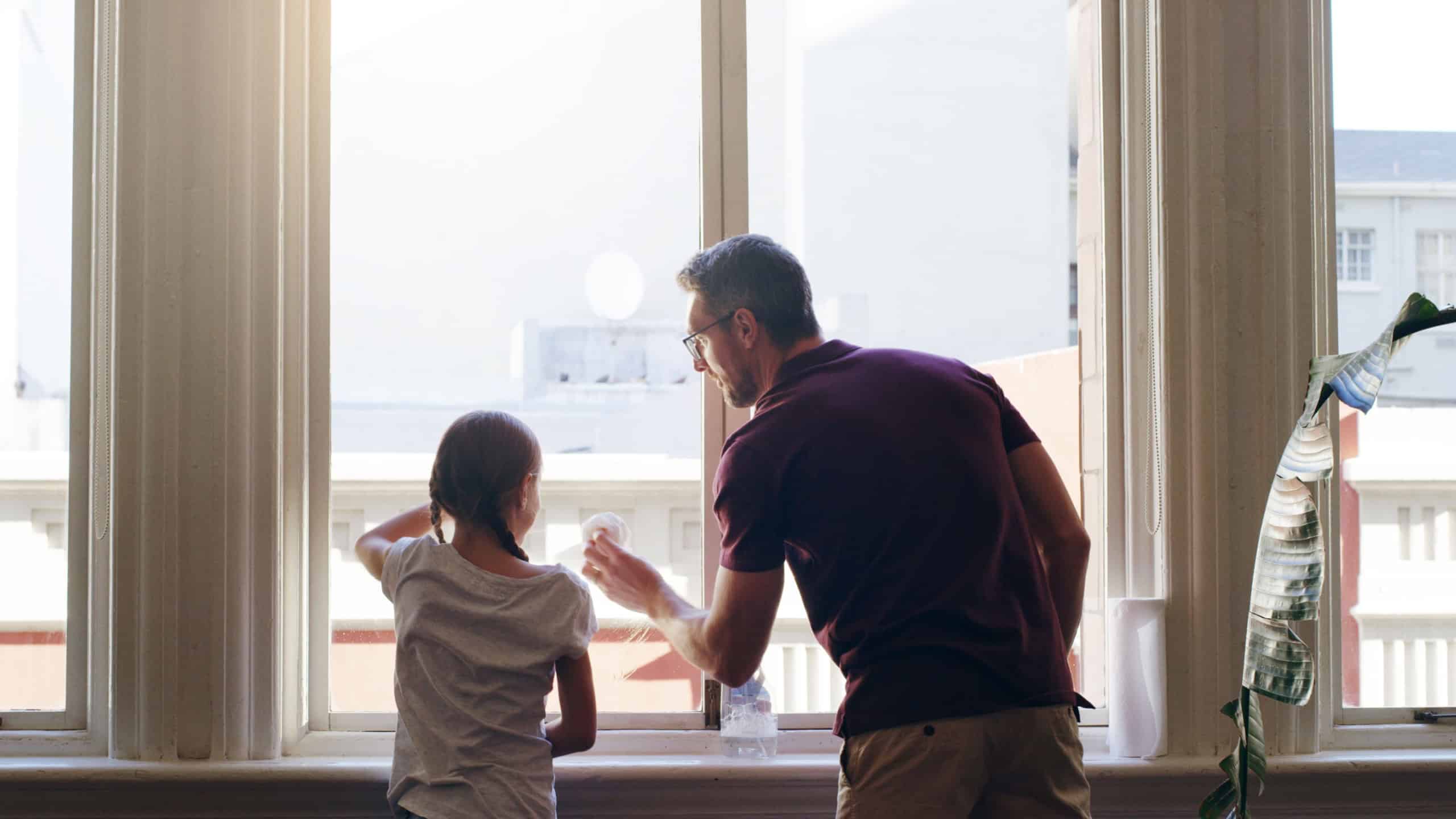 Cleaning window, home and father with girl, back and remove bacteria in lounge. Family, apartment and single parent with daughter, kid and childhood for chores, housekeeping and routine with help