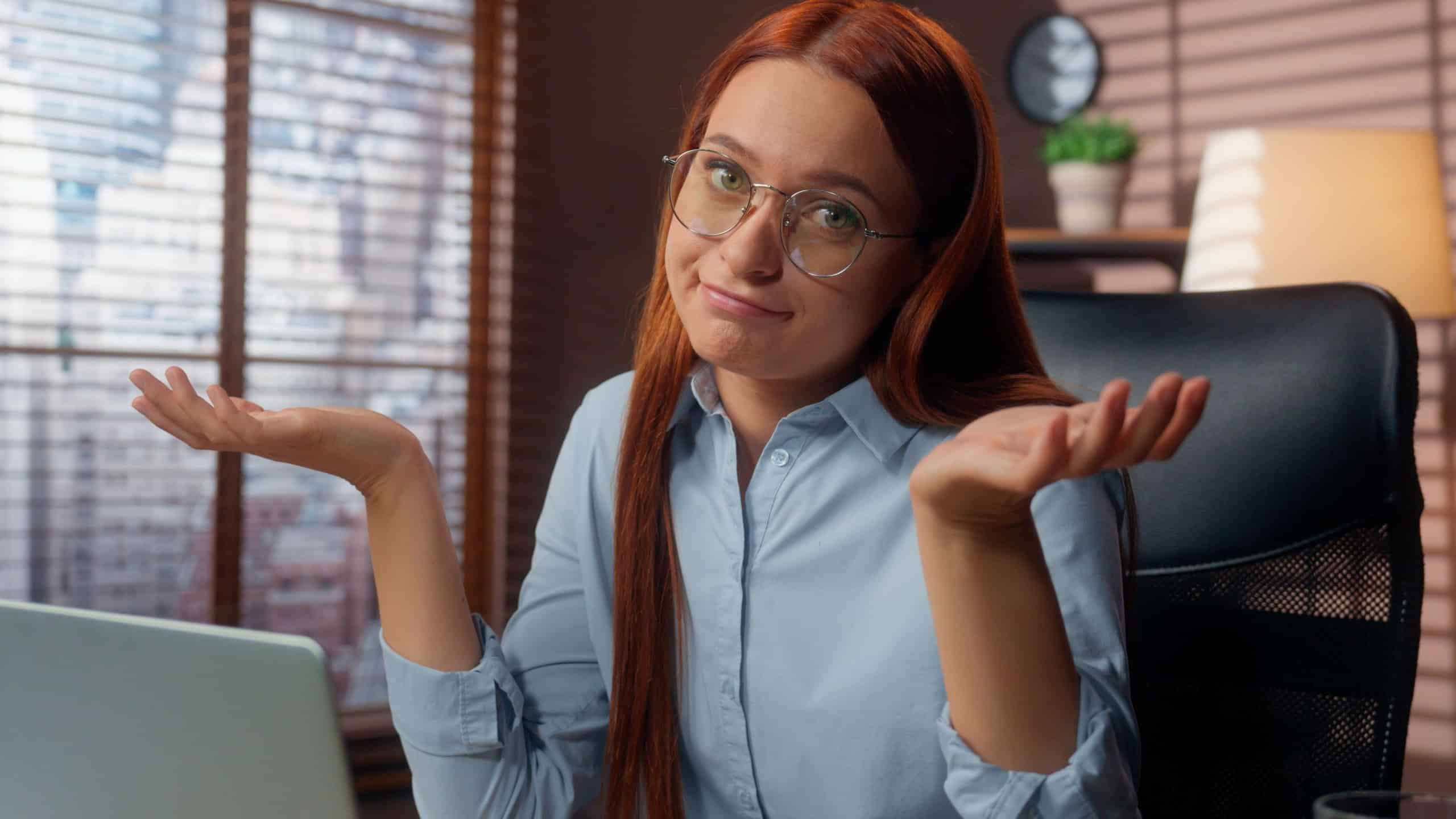 Business woman businesswoman in office working laptop online problem difficult Caucasian female girl shrug shoulders unsure trouble employer manager using computer looking at camera specialist failure
