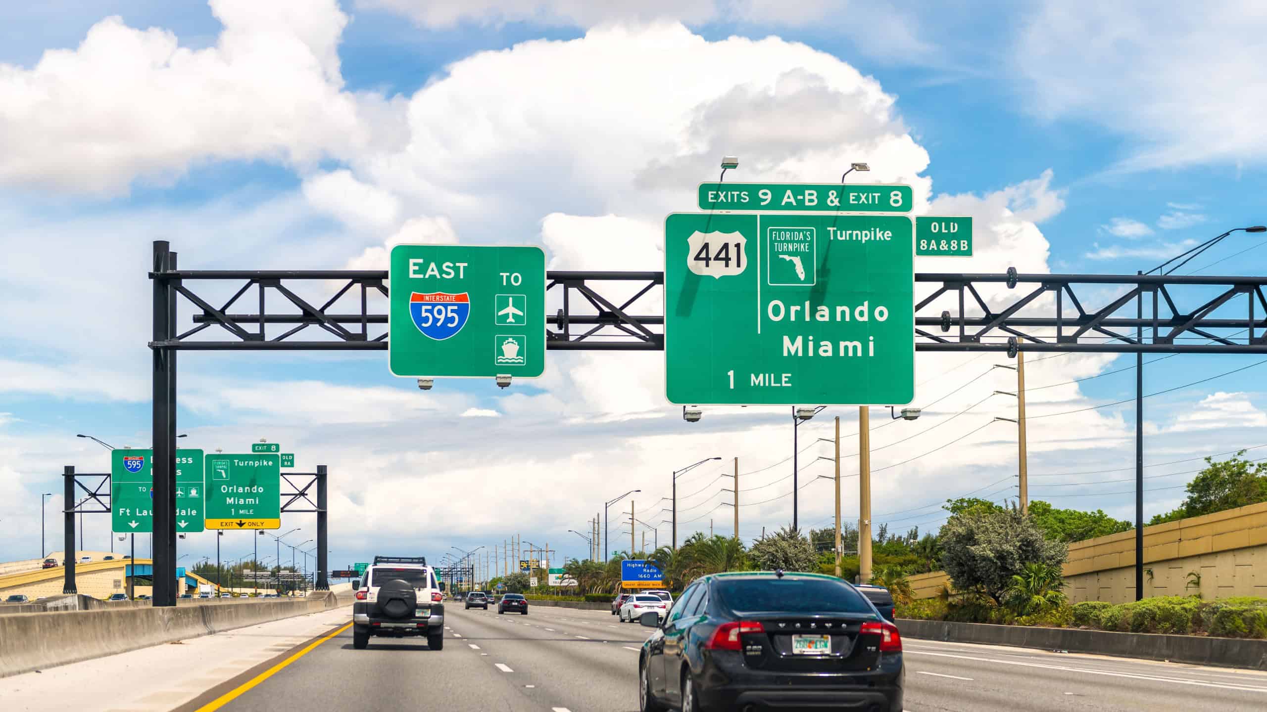 Miami, USA - April 30, 2022: Highway traffic by interstate road 595 east with exit sign to Florida turnpike to Orlando in Miami-Dade county