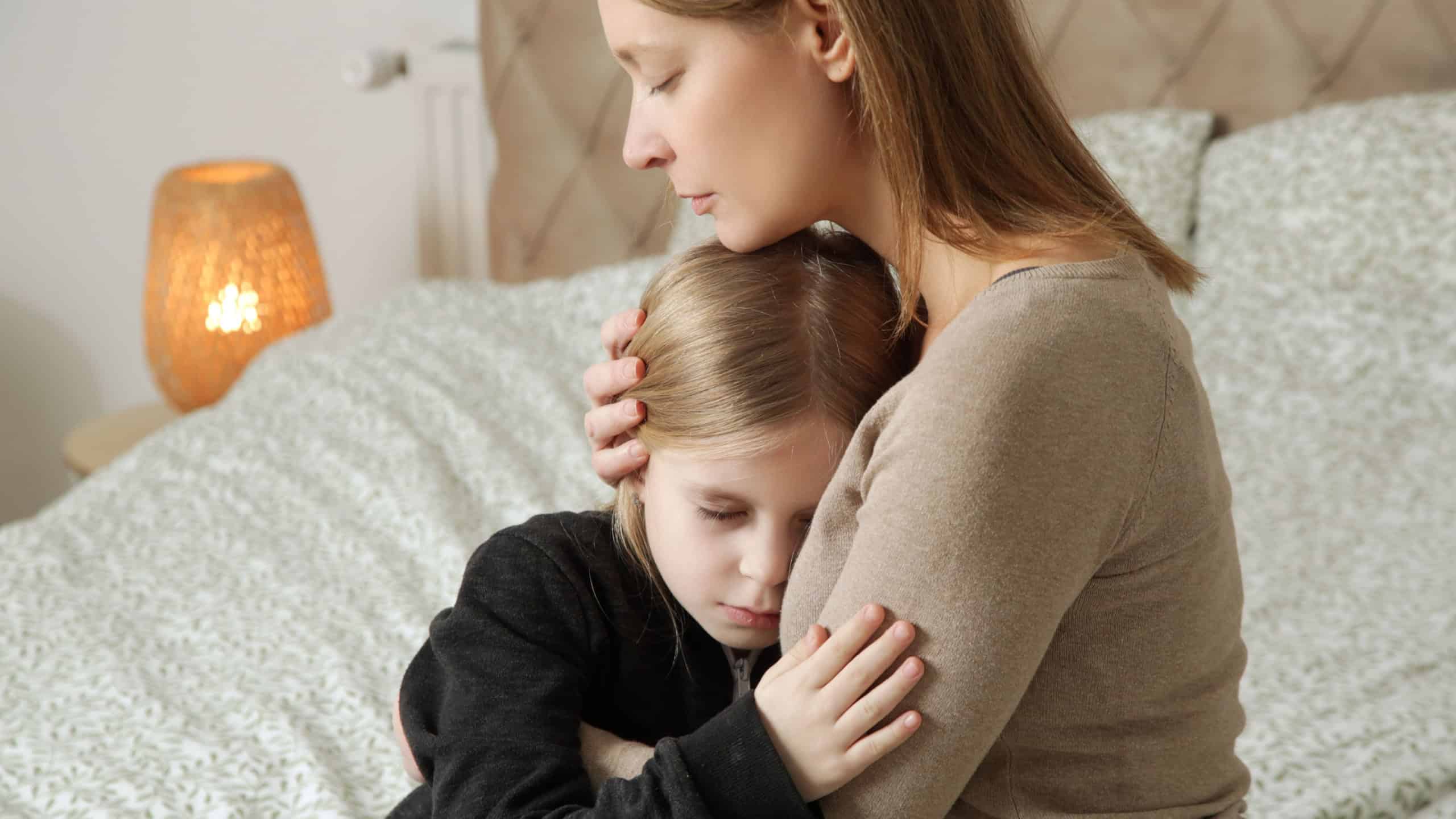 Loving worried mom consoling her sad little girl