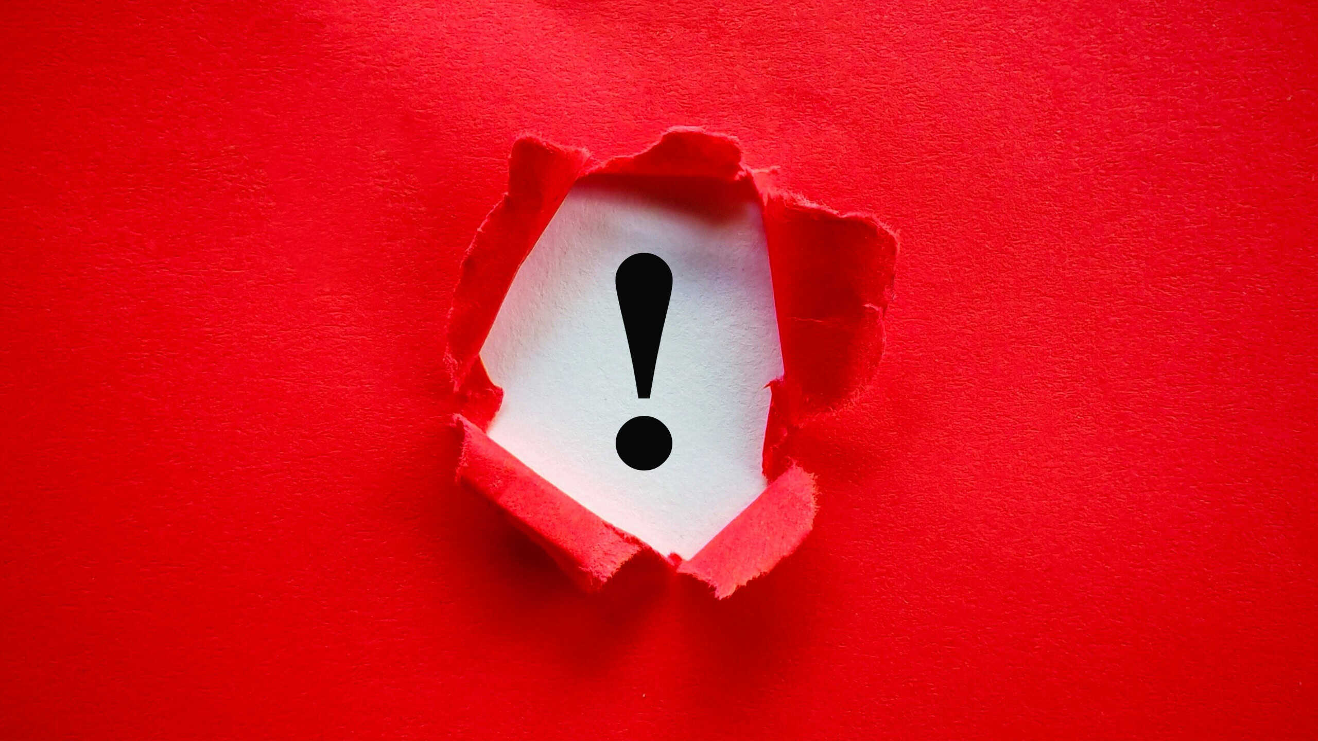 Exclamation Mark Revealed Under Torn Red Paper Showing Important Warning or Alert