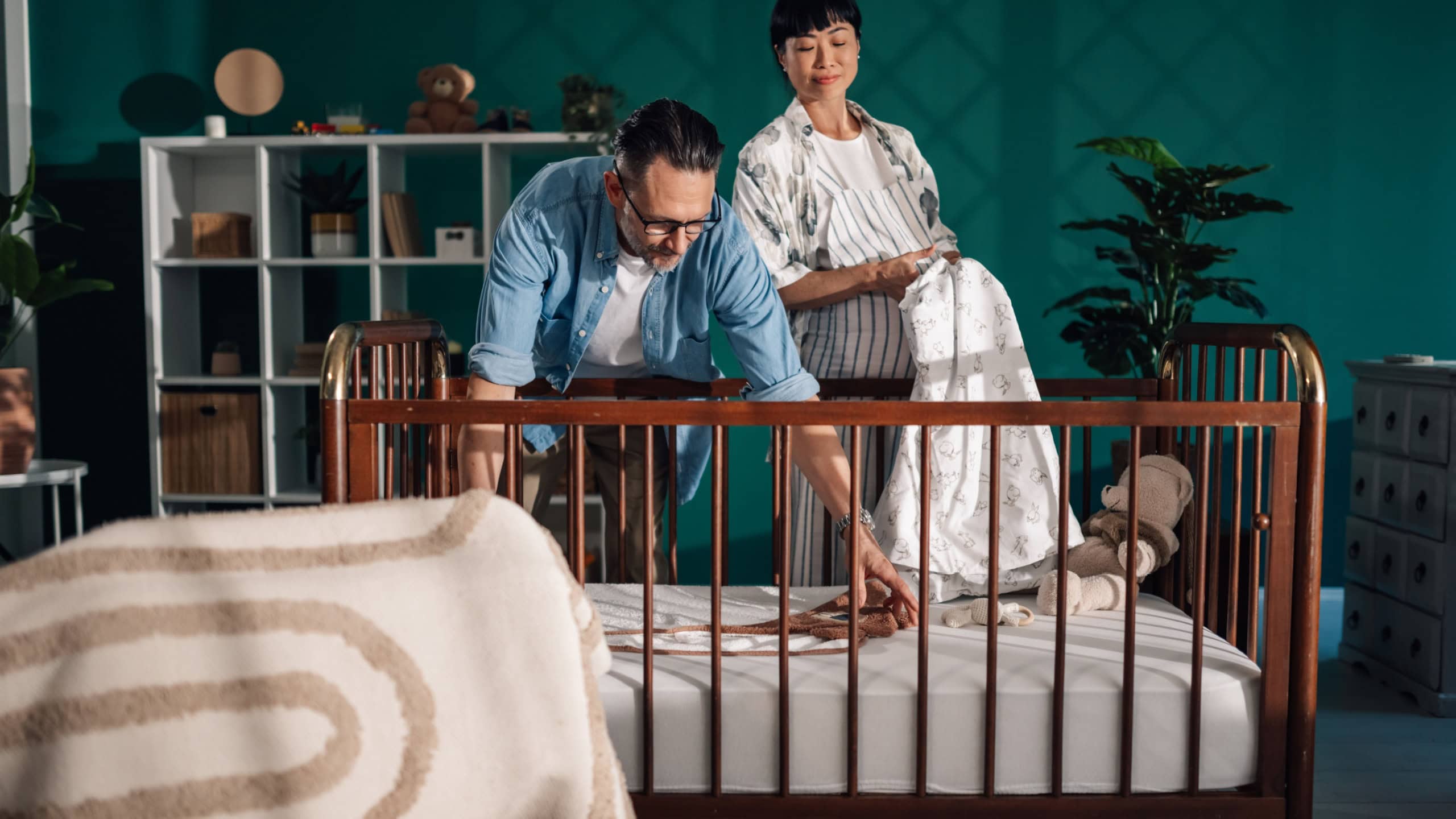 Happy couple arranging baby crib in anticipation of their child's arrival, creating a warm and welcoming nursery