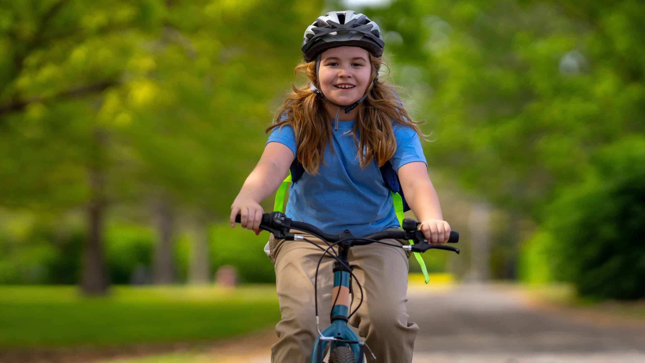 Child bike ride. Teen boy biking down summer road. Kid riding bicycle with smile. Child cycling. Kid ride on bike. Happy boy on bike. Child biking outdoors. Children biking. Little biker.