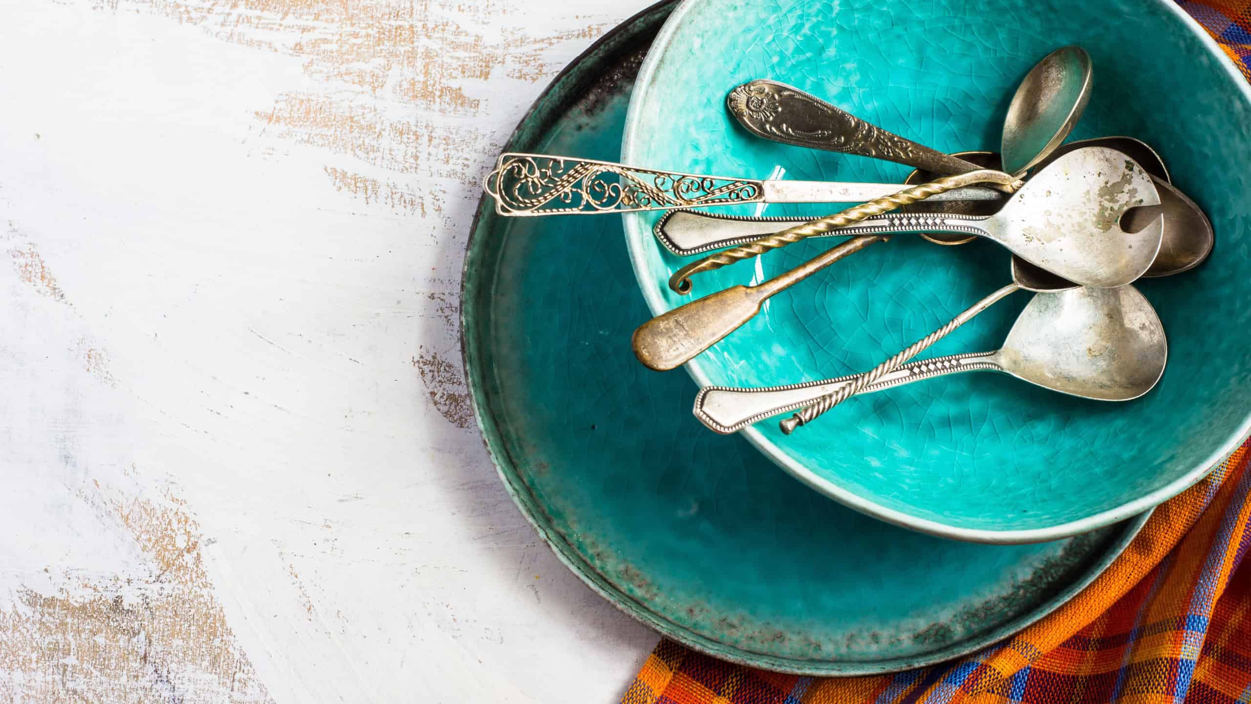 Rustic table setting wit bright napkin, silverware and plate on old wooden table. View from above with copy space