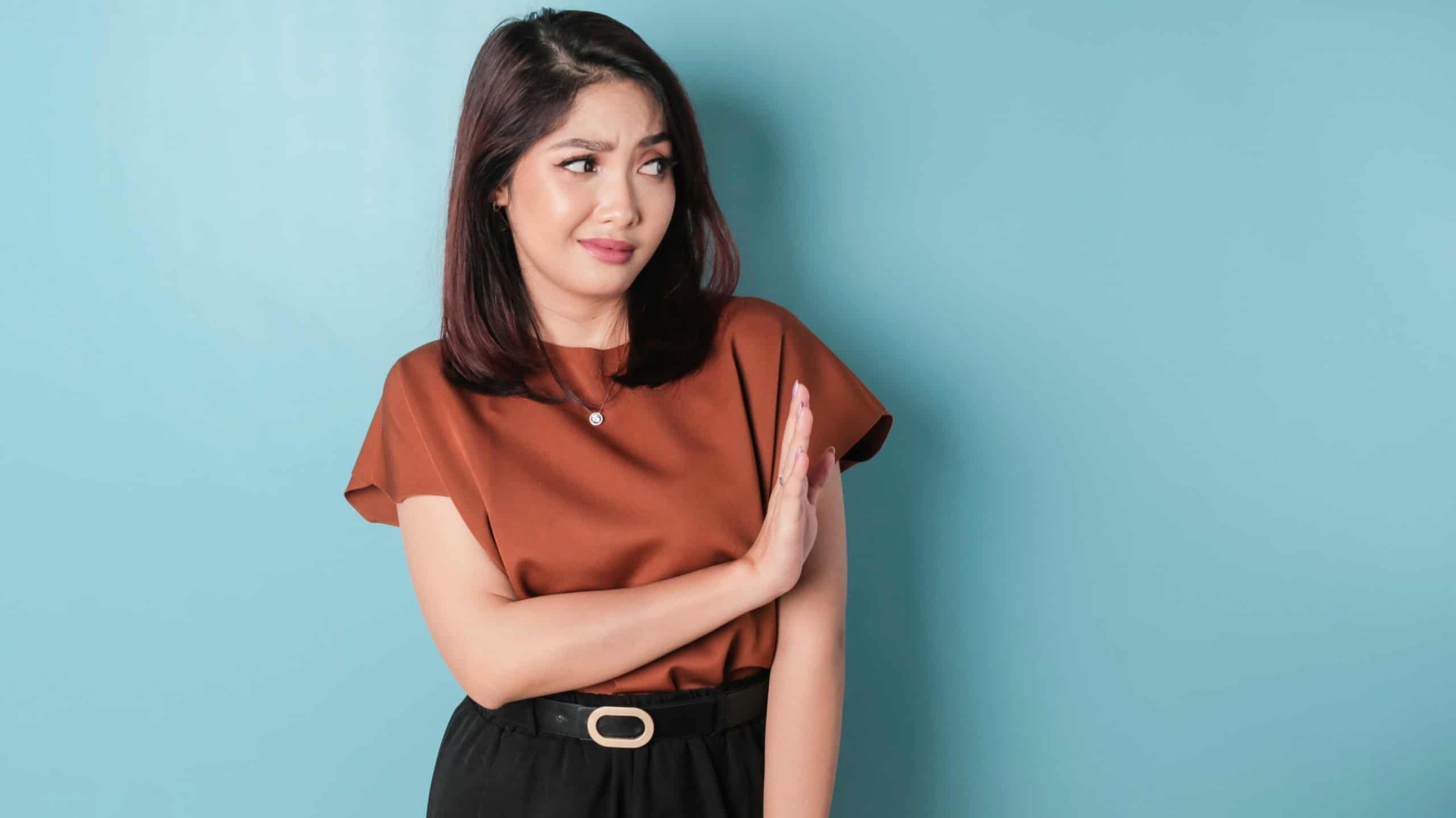 Beautiful Asian woman with hand gesture pose rejecting offer with copy space